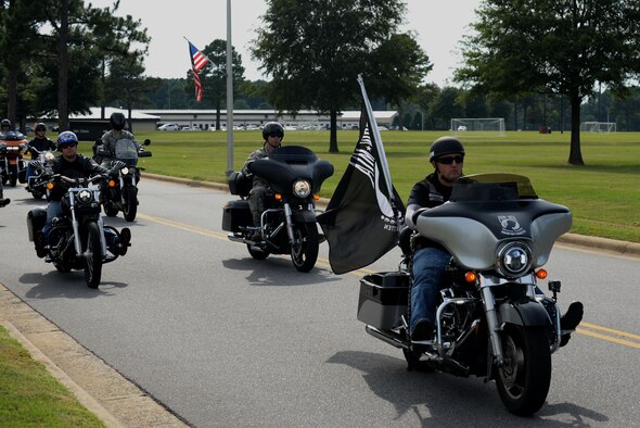 Motorcyclists supporting the Prisoners of War/Missing in Action Remembrance Week lead Airmen as they usher the POW/MIA flag to the ceremony site, Sept. 17, 2015 at Seymour Johnson Air Force Base, North Carolina. The precession began the final event for the week, a ceremony honoring all service members who were lost in action.  (U.S. Air Force photo/Airman 1st Class Ashley Williamson)