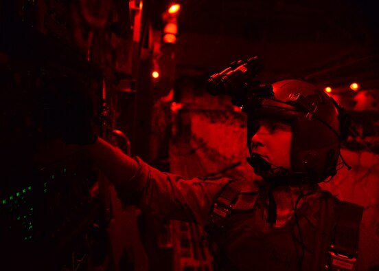 Senior Airman Paul Maginnis prepares to open the back door on a C-17 Globemaster III during a humanitarian air drop of 40 container delivery system bundles filled with fresh drinking water Aug. 31, 2014, over the area of Amirli, Iraq. Lights are dimmed or shut off completely to lower visibility to threats from the ground. The airdrop included two C-17s and two C-130 Hercules delivering 10,545 gallons of fresh drinking water and 7,056 Halal Meals Ready to Eat. Maginnis is a 816th Expeditionary Airlift Squadron loadmaster. (U.S. Air Force photo/Staff Sgt. Shawn Nickel)