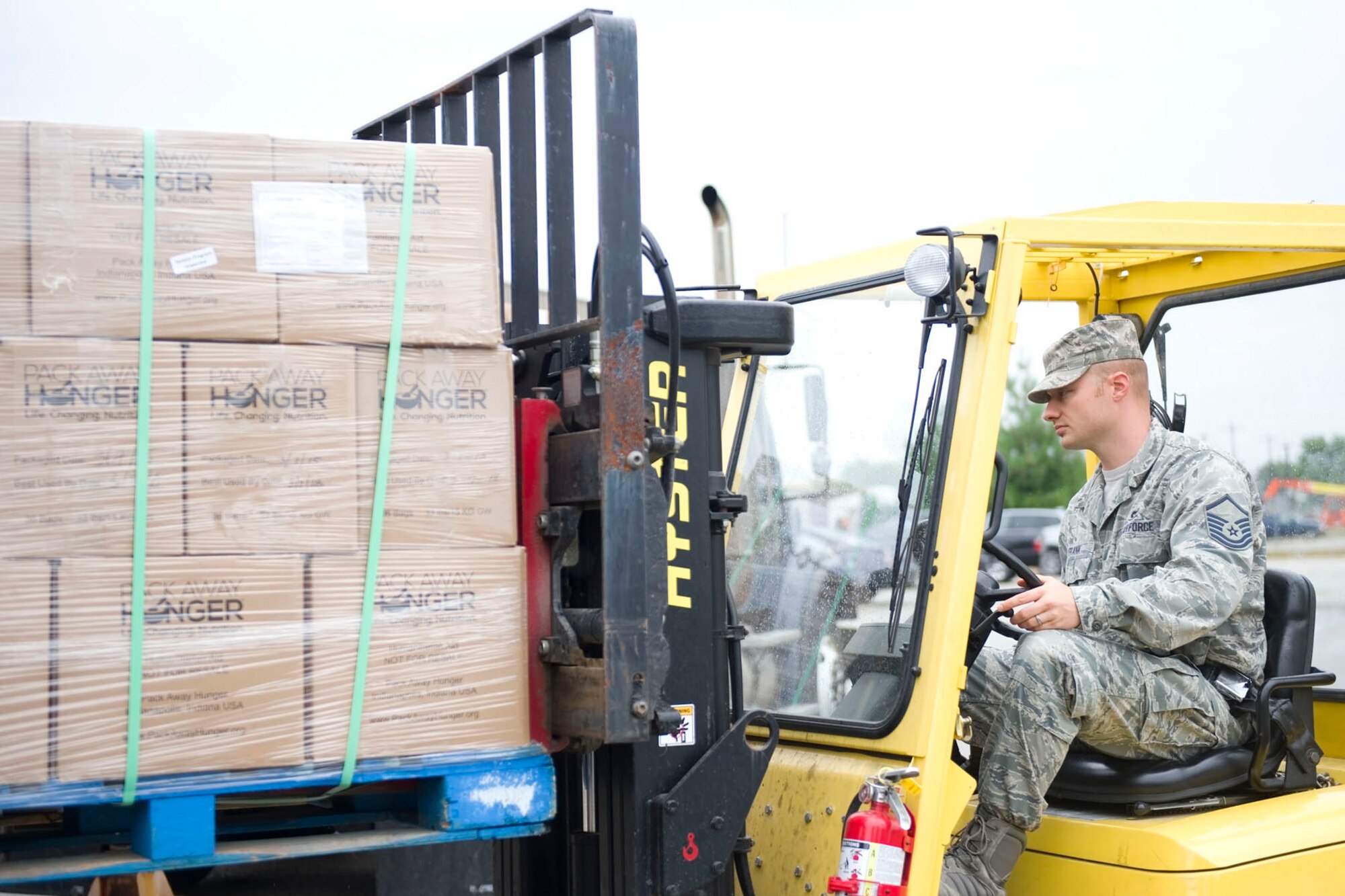 Master Sgt. Bradley Frank, 49th Aerial Port Flight aerial port journeyman, uses a fork lift to load a skid containing packages of food for a humanitarian mission at Grissom Air Reserve Base, Ind., Sept. 12 2015. Under the Denton Program, Grissom Airman stepped up to help deliver 43,000 pounds of food to over 8,500 people in Haiti. (U.S. Air Force photo /Senior Airman Jami K. Lancette)