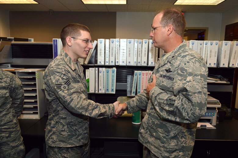 Air Force Brig. Gen. James Scanlan, mobilization assistant to the U.S. Air Force Expeditionary Center commander, presents his coin to Senior Airman Austin Eaton, a command post controller assigned to the 43rd Airlift Group, recognizing his outstanding duty performance. Scanlan visited 43rd AG Airmen during his visit to Pope Army Airfield, North Carolina, Sept. 17-18. (U.S. Air Force photo/Marvin Krause)
