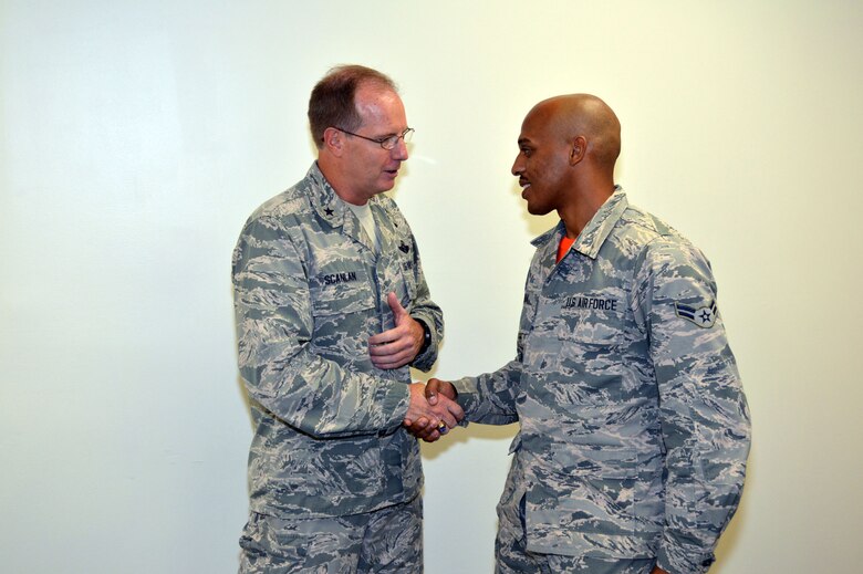 Air Force Brig. Gen. James Scanlan, mobilization assistant to the U.S. Air Force Expeditionary Center commander, presents his coin to Airman 1st Class Anthony Jordan, a supply journeyman assigned to the 43rd Air Base Squadron, recognizing his outstanding duty performance. Scanlan visited 43rd Airlift Group Airmen during his visit to Pope Army Airfield, North Carolina, Sept. 17-18. (U.S. Air Force photo/Marvin Krause)
