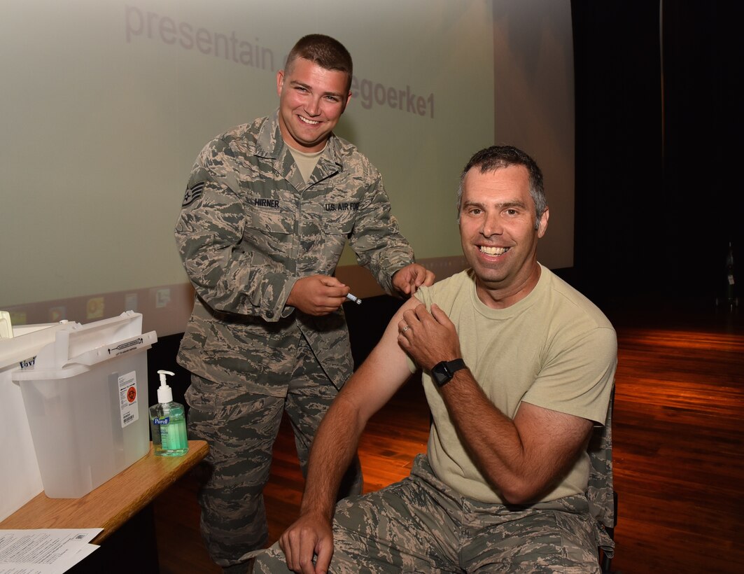 Staff Sergeant Paul Hirner gives the first flu shot of the fall 2015 season to the wing commander, Col. Karl Goerke, during the September Unit Training Assembly.  Shots are a military requirement to help ward off sickness and hopefully stay safer from health complications in the upcoming flu season.