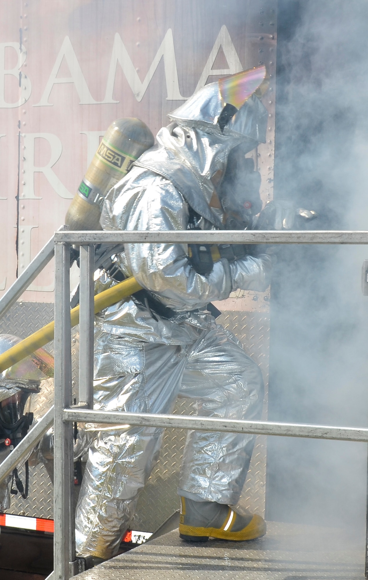 Firefighters from the Civil Engineering Squadron practice fighting structure fires as a part of their annual training at the 117th Air Refueling Wing on September 19, 2015. The firefighters used a travel trailer and other equipment to simulate structure fires caused by propane gas. According to Master Sgt. Brian Garvich, their main strategy in fighting these fires was to utilize the “two-in, two-out” policy which mandates that firefighters never enter a building alone during a rescue mission. Two firefighters act as a team entering the structure and another two-person team is waiting outside the hazard dedicated to rescuing those inside, should they need it. (U.S. Air National Guard photo  by Staff Sgt. Jeremy Farson/Released)