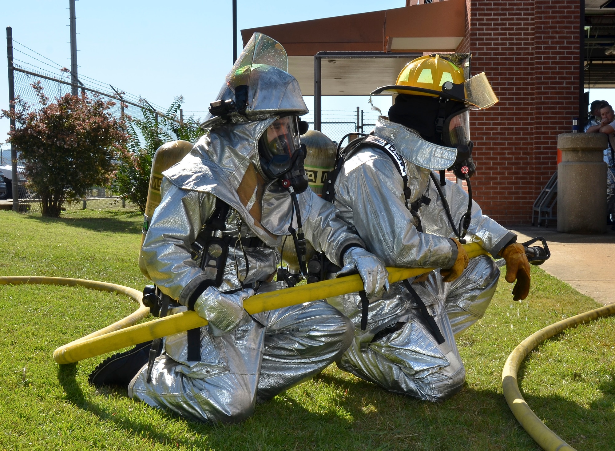 Firefighters from the Civil Engineering Squadron practice fighting structure fires as a part of their annual training at the 117th Air Refueling Wing on September 19, 2015. The firefighters used a travel trailer and other equipment to simulate structure fires caused by propane gas. According to Master Sgt. Brian Garvich, their main strategy in fighting these fires was to utilize the “two-in, two-out” policy which mandates that firefighters never enter a building alone during a rescue mission. Two firefighters act as a team entering the structure and another two-person team is waiting outside the hazard dedicated to rescuing those inside, should they need it. (U.S. Air National Guard photo  by Staff Sgt. Jeremy Farson/Released)