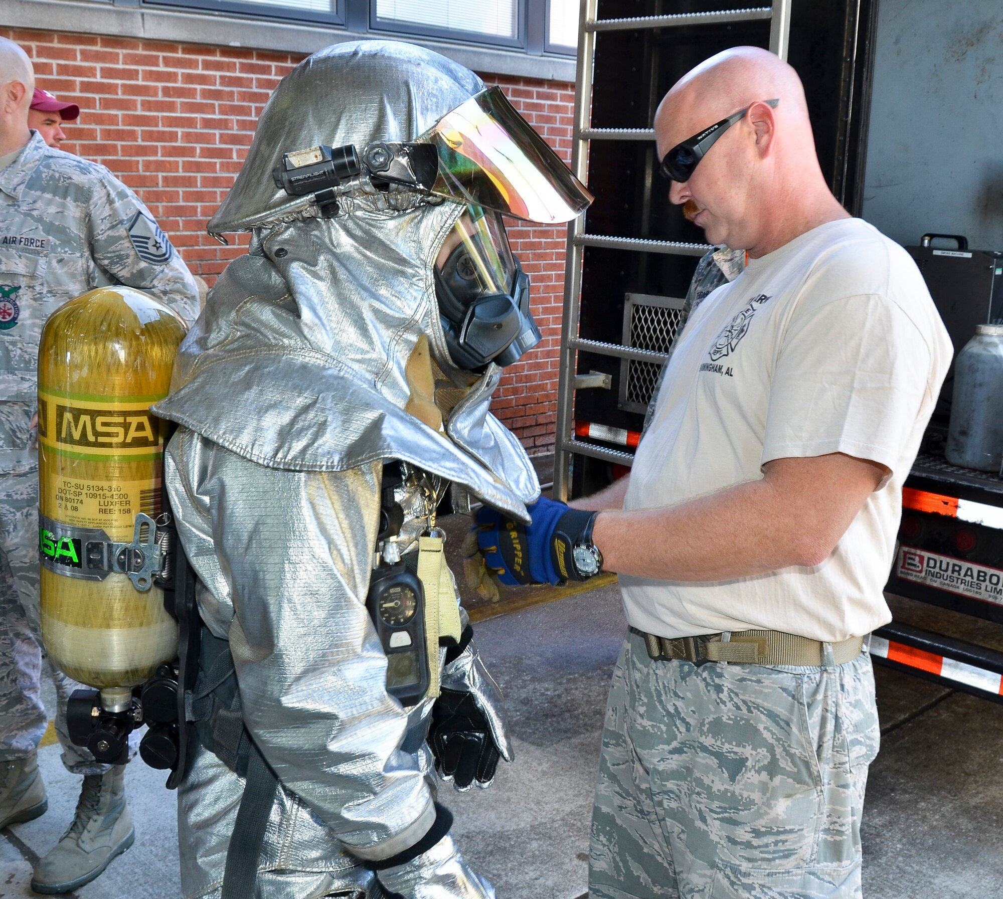Firefighters from the Civil Engineering Squadron practice fighting structure fires as a part of their annual training at the 117th Air Refueling Wing on September 19, 2015. The firefighters used a travel trailer and other equipment to simulate structure fires caused by propane gas. According to Master Sgt. Brian Garvich, their main strategy in fighting these fires was to utilize the “two-in, two-out” policy which mandates that firefighters never enter a building alone during a rescue mission. Two firefighters act as a team entering the structure and another two-person team is waiting outside the hazard dedicated to rescuing those inside, should they need it. (U.S. Air National Guard photo  by Staff Sgt. Jeremy Farson/Released)