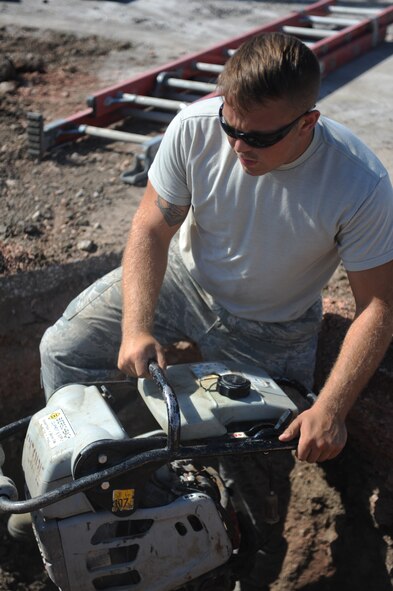 Airman 1st Class Travis Nummerdor, 28th Civil Engineer Squadron pavements and construction technician, compresses dirt at a main fuel storage tank site on Ellsworth Air Force Base, S.D., Sept. 2, 2015. Routine maintenance and inspections of the main fuel storage tank area allow personnel to survey for any leaks or damage, helping prevent harm to the surrounding environment. (U.S. Air Force photo by Airman Sadie Colbert/Released)