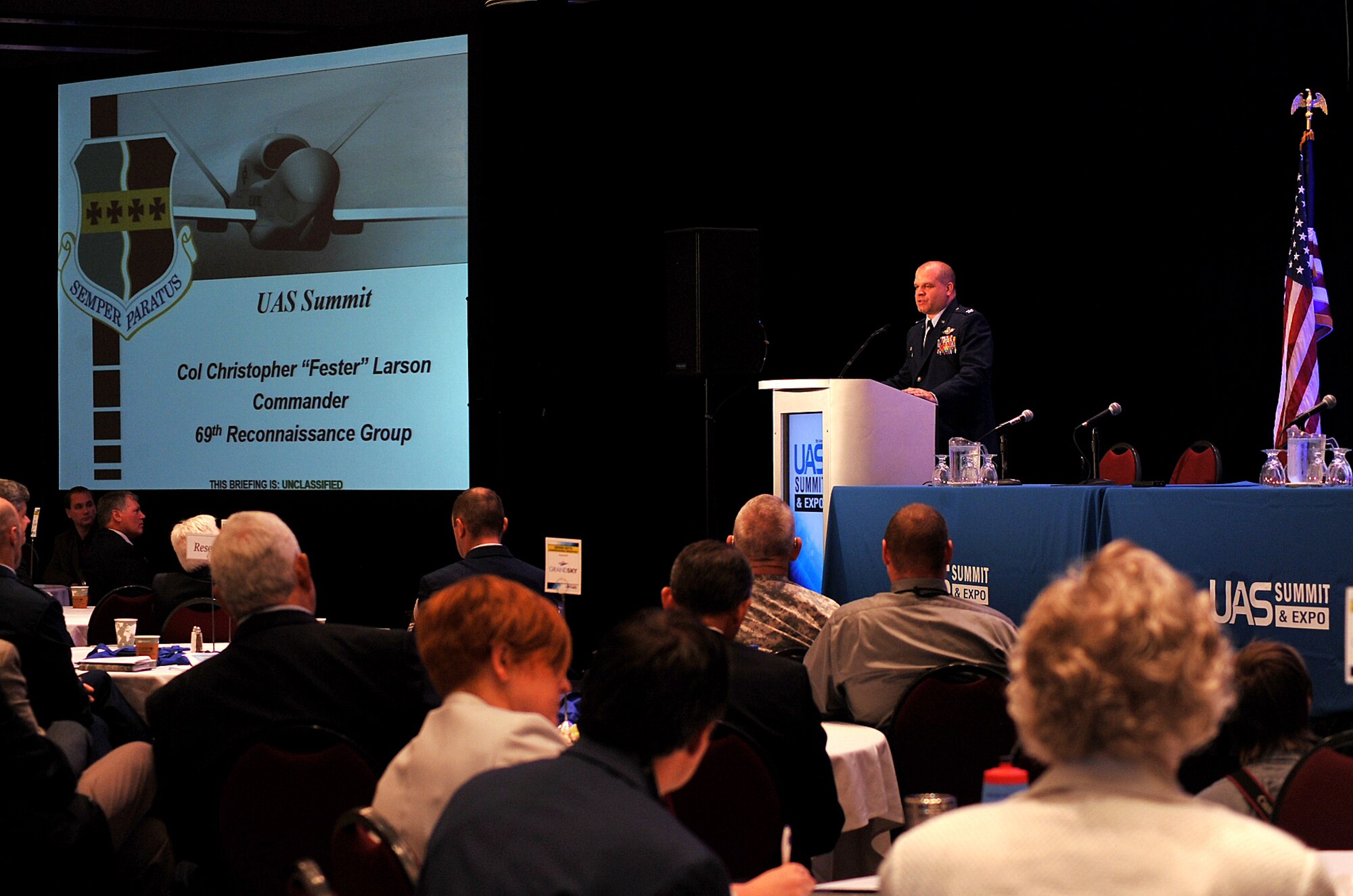 Col. Christopher Larson, 69th Reconnaissance Group commander, informs attendees at the Ninth Annual UAS Summit and Expo Grand Sky Congressional Breakfast of the affordability and long-term sustainment of the RQ-4 Global Hawk in Grand Forks, North Dakota, Sept. 21, 2015. The Congressional Breakfast drew in an audience of more than 200 people including representatives from the governor’s office and North Dakota senators. (U.S. Air Force photo by Airman 1st Class Bonnie Grantham/released)