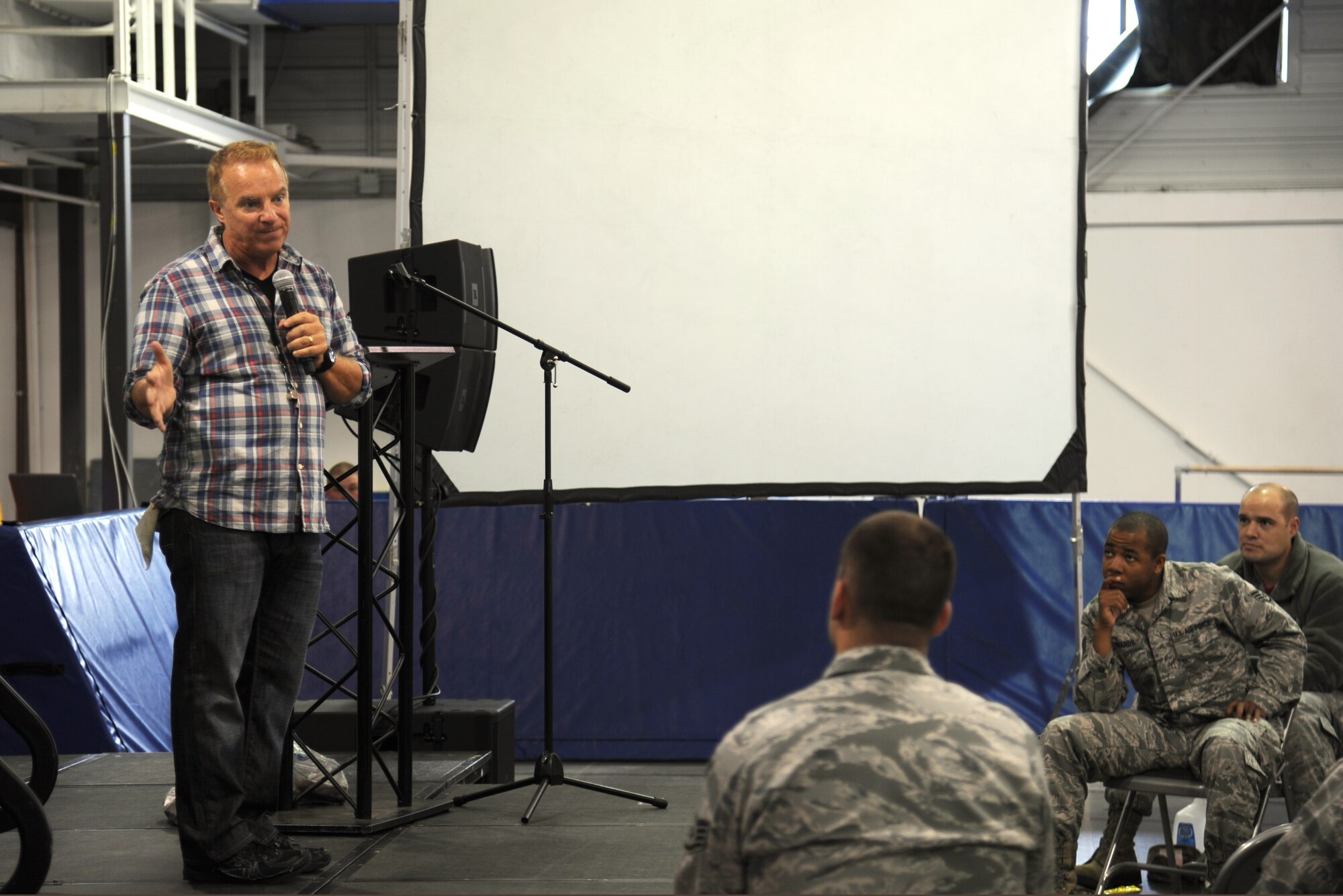 Steve Verret, comedian, speaks to an audience at Liberty Square Sept. 18, 2015, on Grand Forks Air Force Base, North Dakota. Verret's comedic skit, Twist on Safety, gave Airmen insight on safe driving. The audience was split into two groups who answered questions about driving statistics, which ranged from who are the safest drivers and which cars are more susceptible to accidents. (U.S. Air Force photo by Senior Airman Desiree Economides/Released)