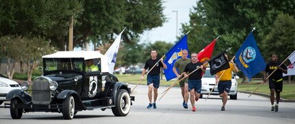 Chief Master Sgt. Kristopher Berg, 437th Airlift Wing command chief, leads the way with the POW/MIA flag during the end of the 24 hour Vigil Run Sept. 18, 2015. The ceremony at the base flagpole on Joint Base Charleston – Air Base, S.C. included a 21-gun salute by the Honor Guard, a wreath-laying and a live bugle performance in recognition of captured and missing U.S. servicemembers. (U.S. Air Force photo/Airman 1st Class Clayton Cupit)