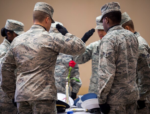 A Joint Base Charleston Honor Guard team salutes the POW/MIA table Sept. 18, 2015, at the Charleston Club on JB Charleston – Air Base, S.C. The POW/MIA table is symbolic of members of the armed forces who have become prisoners of war in foreign countries as well as those who are missing and unaccounted for. (U.S. Air Force photo/Airman 1st Class Clayton Cupit)