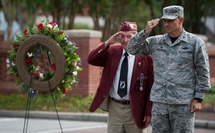 Col. John Lamontagne, 437th Airlift Wing commander and Reggie Salisbury, A U.S. Army infantry veteran, D-Day survivor and World War II prisoner of war salute after laying a wreath during the POW/MIA retreat ceremony Sept. 18, 2015, at the base flagpole on Joint Base Charleston – Air Base, S.C. The ceremony also included a 21-gun salute by the Honor Guard and a live bugle performance in recognition of captured and missing U.S. servicemembers. (U.S. Air Force photo/Airman 1st Class Clayton Cupit)