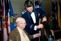 Col. Jason Armagost, 5th Bomb Wing Commander, presents Leo Makelky, World War II veteran and 2015 Air Force ball speaker, a flight jacket at the Air Force ball at Minot AFB, N.D., Sept. 19, 2015. The Air Force ball celebrates the birth of the U.S. Air Force which was created on Sept. 18, 1947. (U.S. Air Force photo by 2d Lt. Kylee Ashton)

