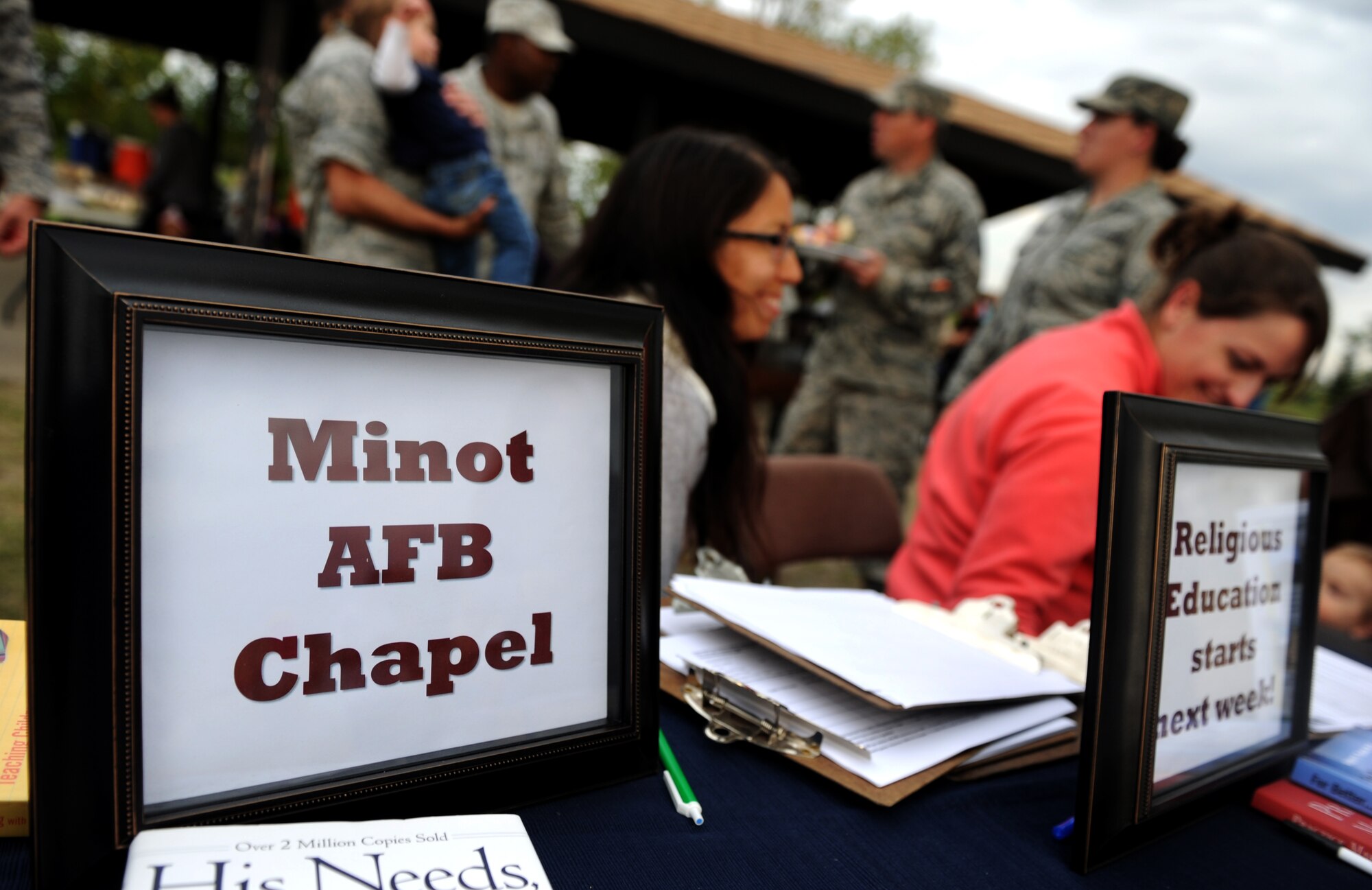 An information table for the chapel at Bud Ebert Park at Minot AFB, N.D. Sept. 16, 2015. The base chapel handed out information about programs that they provide as part of a carnival they put on for the Airmen and their families of Minot AFB. (U.S. Air Force photo by Staff Sgt. Chad Trujillo)
