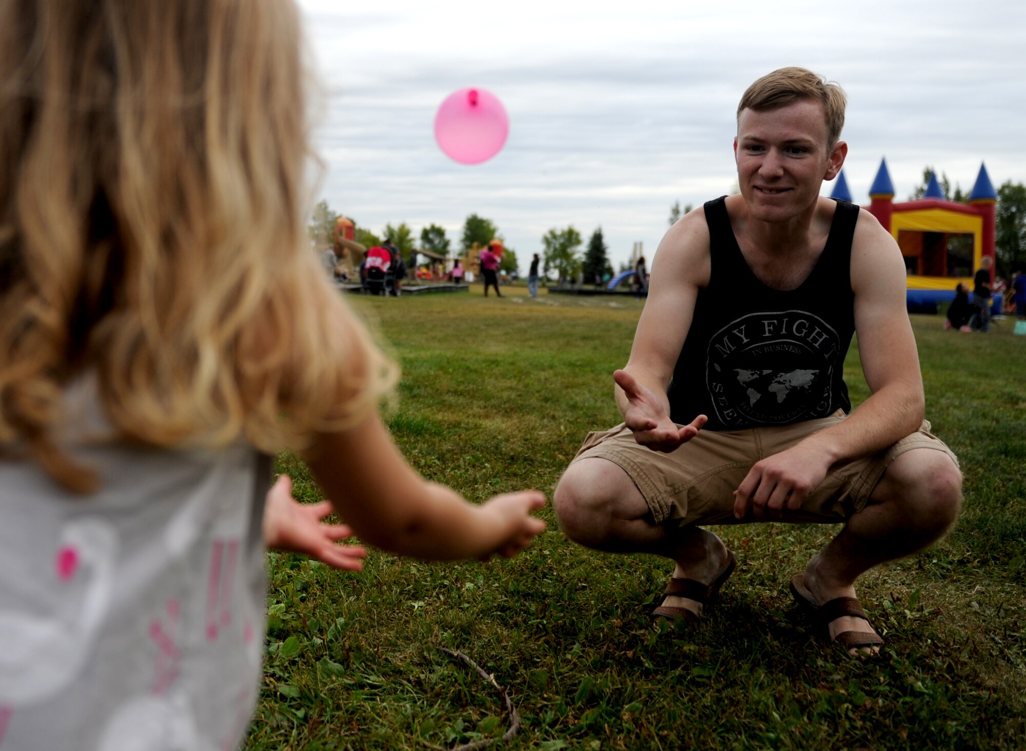 Airman 1st Class Author Rifenbury, 5th Aircraft Maintenance Squadron, plays water balloon catch with Qwynn Trujillo at Bud Ebert Park on Minot AFB, N.D. Sept. 16, 2015. Rifenbury volunteered to help with the carnival that base chapel put on for the Airmen and their families of Minot AFB. (U.S. Air Force photo by Staff Sgt. Chad Trujillo)