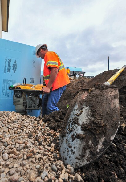 William Marier, contractor, levels dirt for a new airfield lighting system building sidewalk at Minot Air force Base, N.D., Sept. 17, 2015. Marier has been working on the project, which is slated for completion in July 2016, for approximately two months. (U.S. Air Force photo/Senior Airman Stephanie Morris)