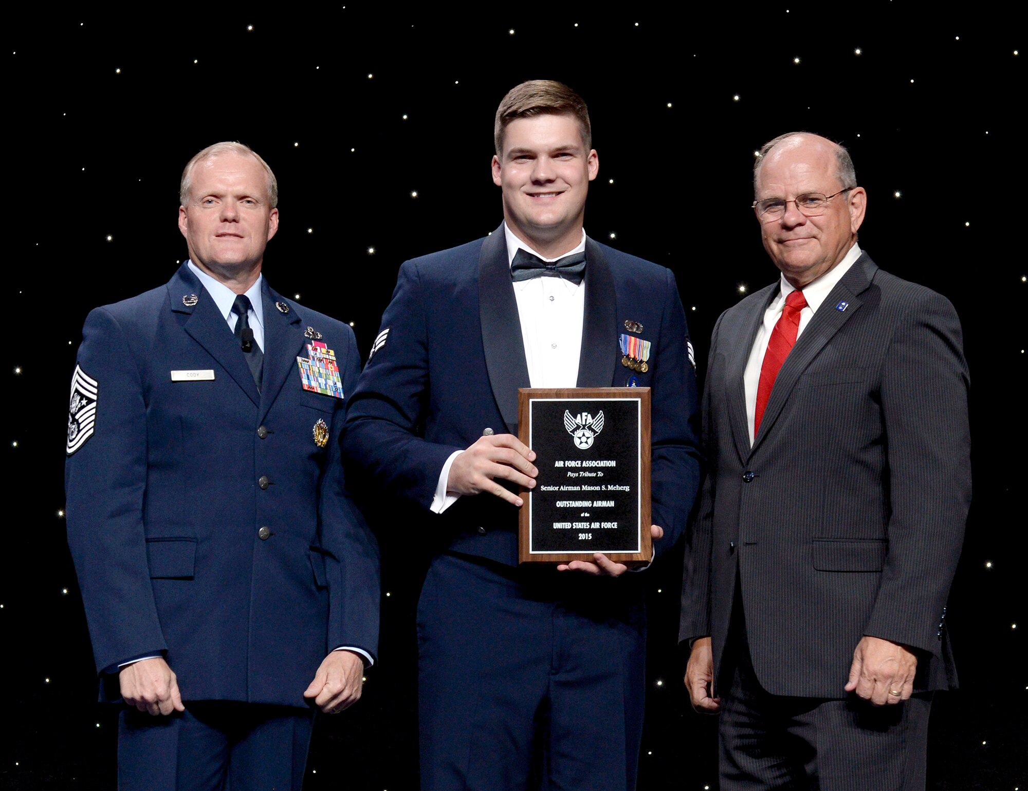 Chief Master Sgt. of the Air Force James Cody and Air Force Association Vice Chairman of the Board Scott Van Cleef flank Senior Airman Mason Meherg at an award ceremony during which Meherg was officially honored as a member of the 12 Outstanding Airmen of the Year at National Harbor, Md., September 14, 2015. (Air Force photo Andy Morataya)
