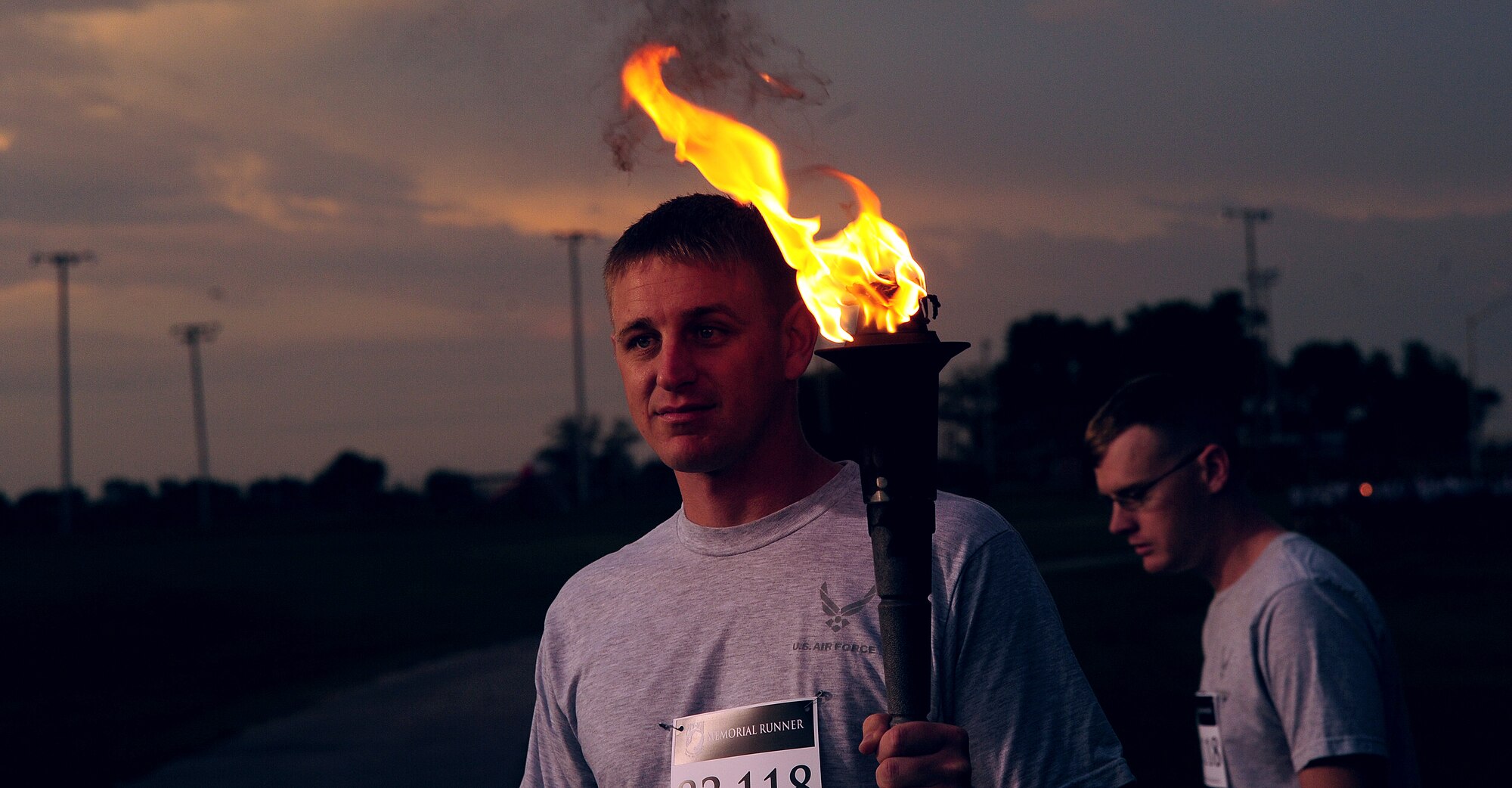 A member of Team Whiteman holds the ceremonial torch as the runners prepare for a 24-hour Prisoners of War/Missing in Action run at Whiteman Air Force Base, Mo., Sept.18, 2015. Congress has designated the third Friday of September as a day to commemorate the POWs and Service members missing in action. (U.S. Air Force photo by Airman 1st Class Jovan Banks/Released)