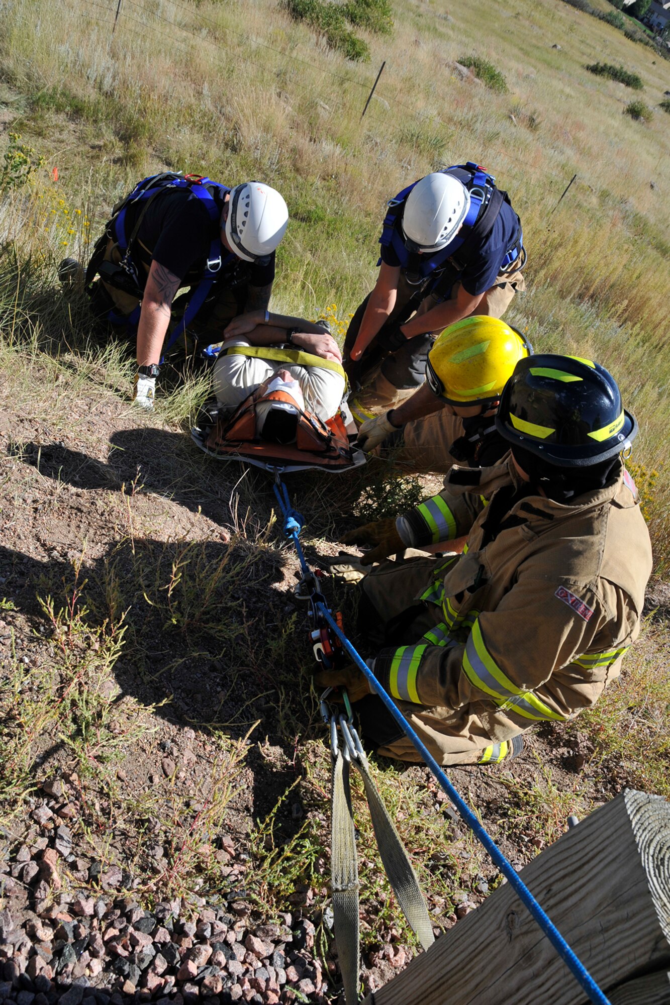 CHEYENNE MOUNTAIN AIR FORCE STATION, Colo. – Emergency responders here aid a simulated accident victim during a response exercise Sept. 17, 2015. The scenario included a bicyclist hit by a car and going over the edge of the mountain. (U.S. Air Force photo by Robb Lingley)