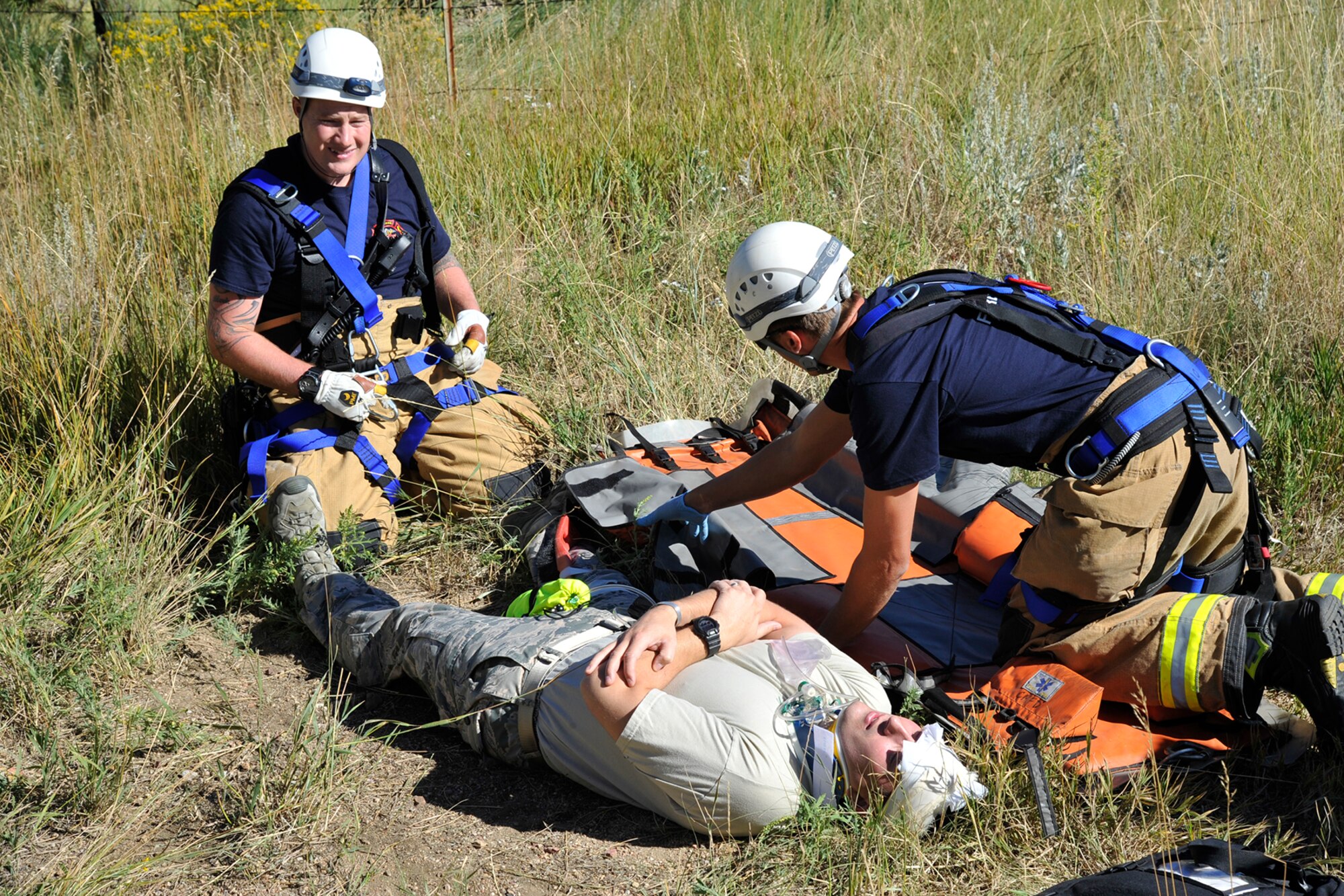 CHEYENNE MOUNTAIN AIR FORCE STATION, Colo. – Emergency responders here aid a simulated accident victim during a response exercise Sept. 17, 2015. The scenario included a bicyclist hit by a car and going over the edge of the mountain. (U.S. Air Force photo by Robb Lingley)