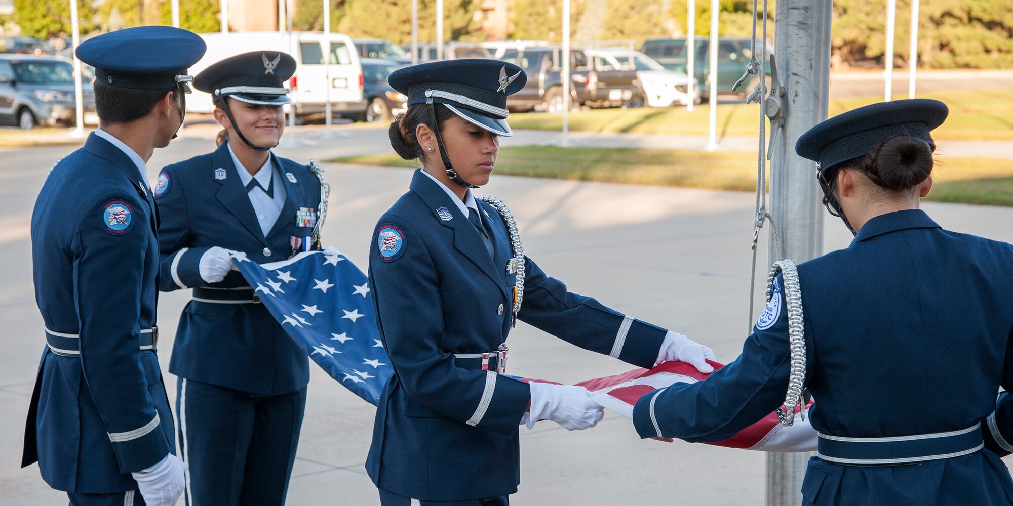 PETERSON AIR FORCE BASE, Colo. -- Members of the Mitchell High School Air Force Junior ROTC color guard unfold and prepare to raise the United States Flag on Peterson Air Force Base on Sept. 16, 2015. This early morning gathering kicked off the remembrance and began the National Prisoner of War/Missing in Action Recognition that is observed from Sept. 17-18. (U.S. Air Force photo by Craig Denton)