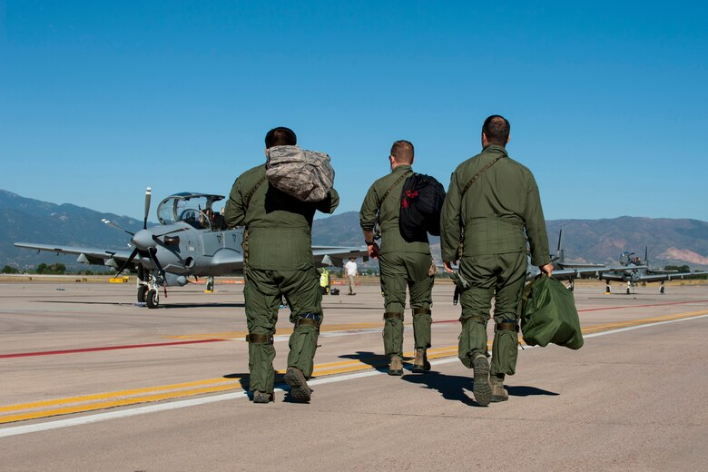 PETERSON AIR FORCE BASE, Colo. – Two pilots from the 81st Fighter Squadron out of Moody Air Force Base, Ga. and an Afghan pilot walk to several A-29B Super Tucanos to prepare  for high altitude training Sept. 16, 2015 here. Four Afghani pilots have been training with the 81st FS on the aircraft since January in Georgia and came to Peterson to get training and experience in high altitude and mountainous terrain. After the training, both the American and Afghan pilots will go to Afghanistan to help establish fighter squadrons. (U.S Air Force photo by Airman 1st Class Rose Gudex)
