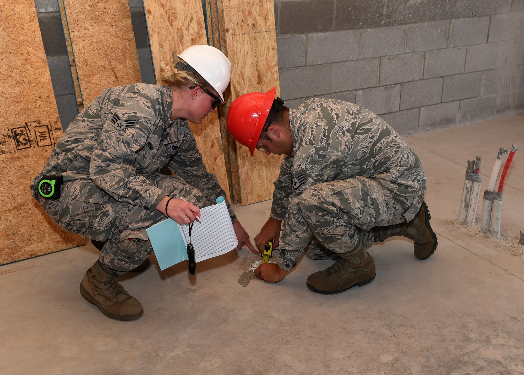 ALTUS AIR FORCE BASE, Okla. – U.S. Air Force Senior Airman Brooke Byerley, who is the lead draftsman for the project, and U.S. Air Force Staff Sgt. Shawn Tesh, 97th Civil Engineer Squadron water fuels craftsman, inspect a drain during construction of a new entomology facility, Sept. 21, 2015, to ensure it has the right slope and will drain correctly. This project fulfills the annual 97th CES requirement for contingency training as well as provides the entomology shop with a facility that is up to code. (U.S. Air Force photo by Airman 1st Class Megan E. Acs/Released)