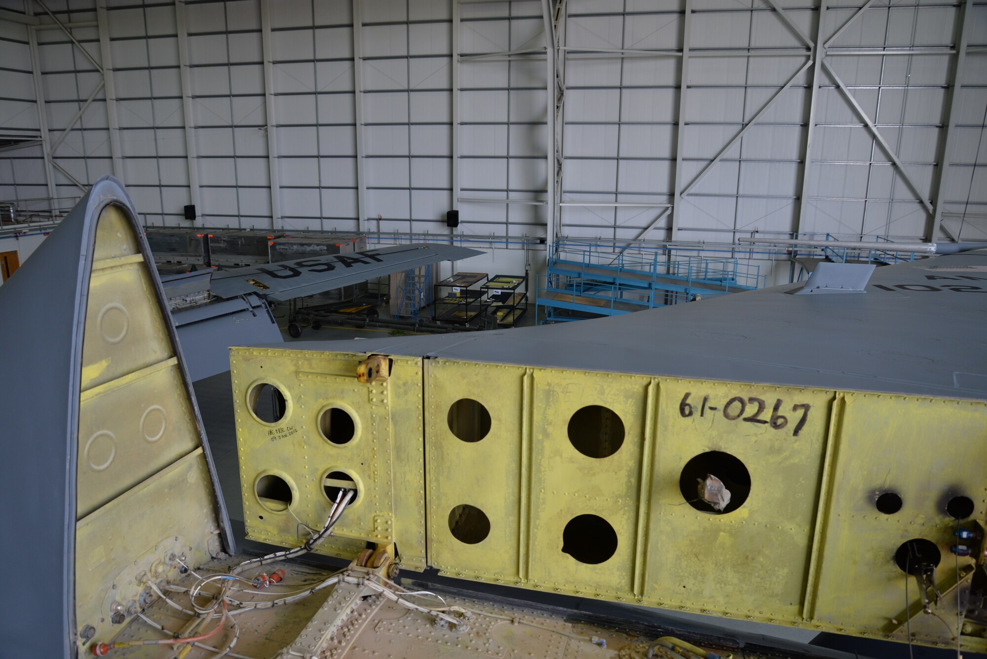 The underside of a KC-135 Stratotanker tail lays horizontal before the final bolts are unfastened to allow its removal Sept. 11, 2015, on RAF Mildenhall, England. The jet was undergoing a full isochronal inspection, which included a “fin fold” and removal of the tail in order to repair a cracked rudder. Once full maintenance is complete, the aircraft will be repainted and become part of RAF Mildenhall’s fleet of refuelers. (U.S. Air Force photo by Karen Abeyasekere/Released)