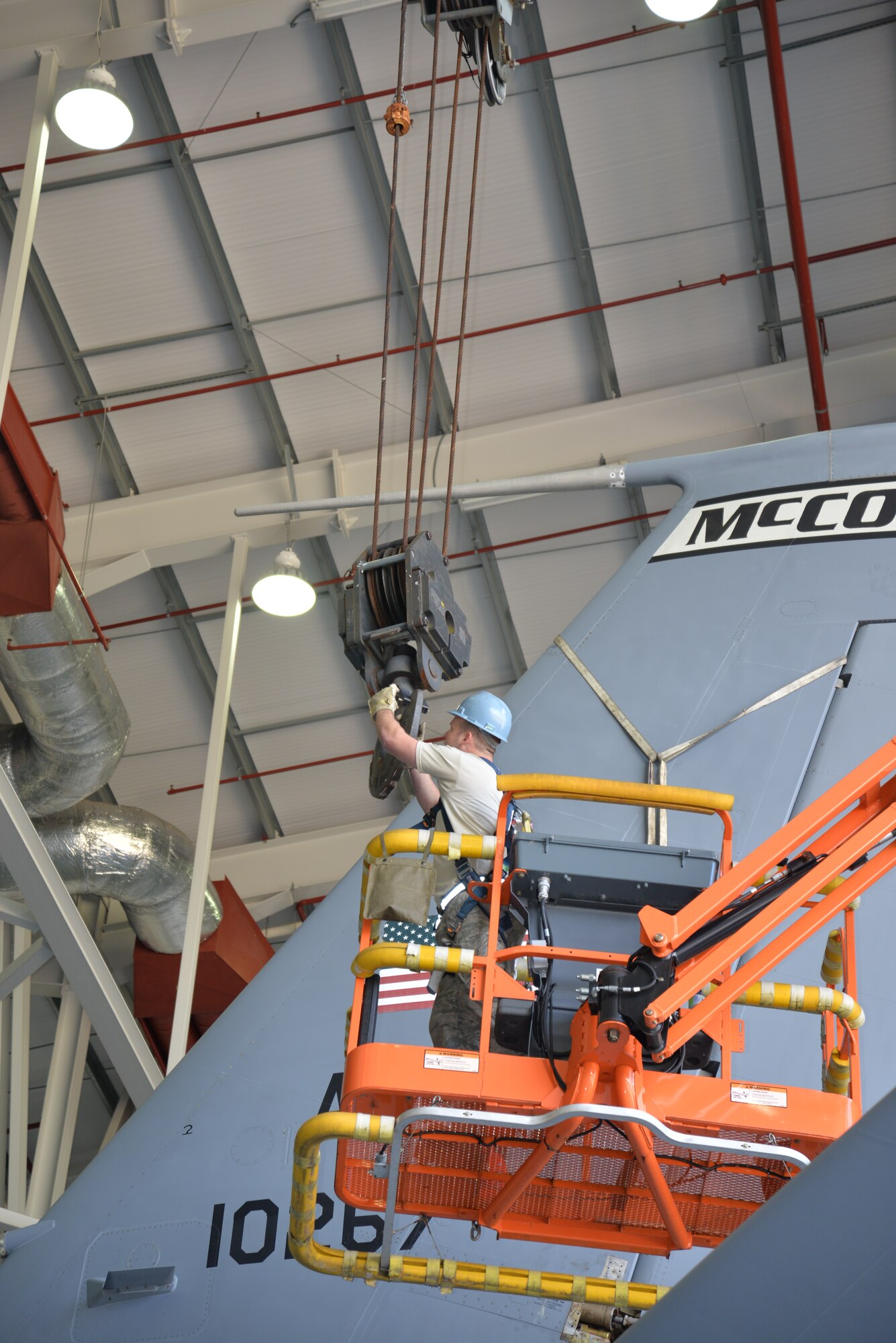 U.S. Air Force Staff Sgt. Christopher Ward, 100th Maintenance Squadron repair and reclamation crew chief, connects a crane hook to chains attached to the tail of a KC-135 Stratotanker in preparation for removal of the tail Sept. 11, 2015, on RAF Mildenhall, England. The jet, formerly from McConnell Air Force Base, has been reassigned to RAF Mildenhall and underwent a full isochronal inspection, with the addition of the tail removal.  It will soon be repainted and given the Square D markings. (U.S. Air Force photo by Karen Abeyasekere/Released)