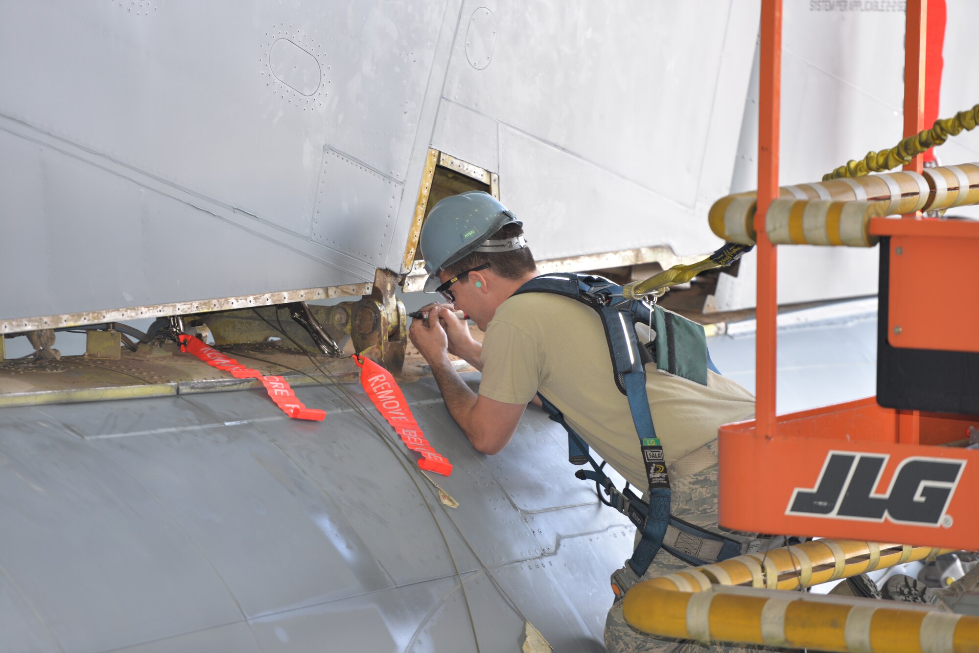 U.S. Air Force Senior Airman Kelly Huddleston, 100th Maintenance Squadron aircraft metals technician, removes stuck hardware at the base of a KC-135 Stratotanker tail before a fin-fold process and tail removal Sept. 11, 2015, on RAF Mildenhall, England. Twenty-five U.S. Air Force Airmen from the 100th Maintenance Squadron and 100th Aircraft Maintenance Squadron worked together round-the-clock to accomplish the major task. (U.S. Air Force photo by Karen Abeyasekere/Released)