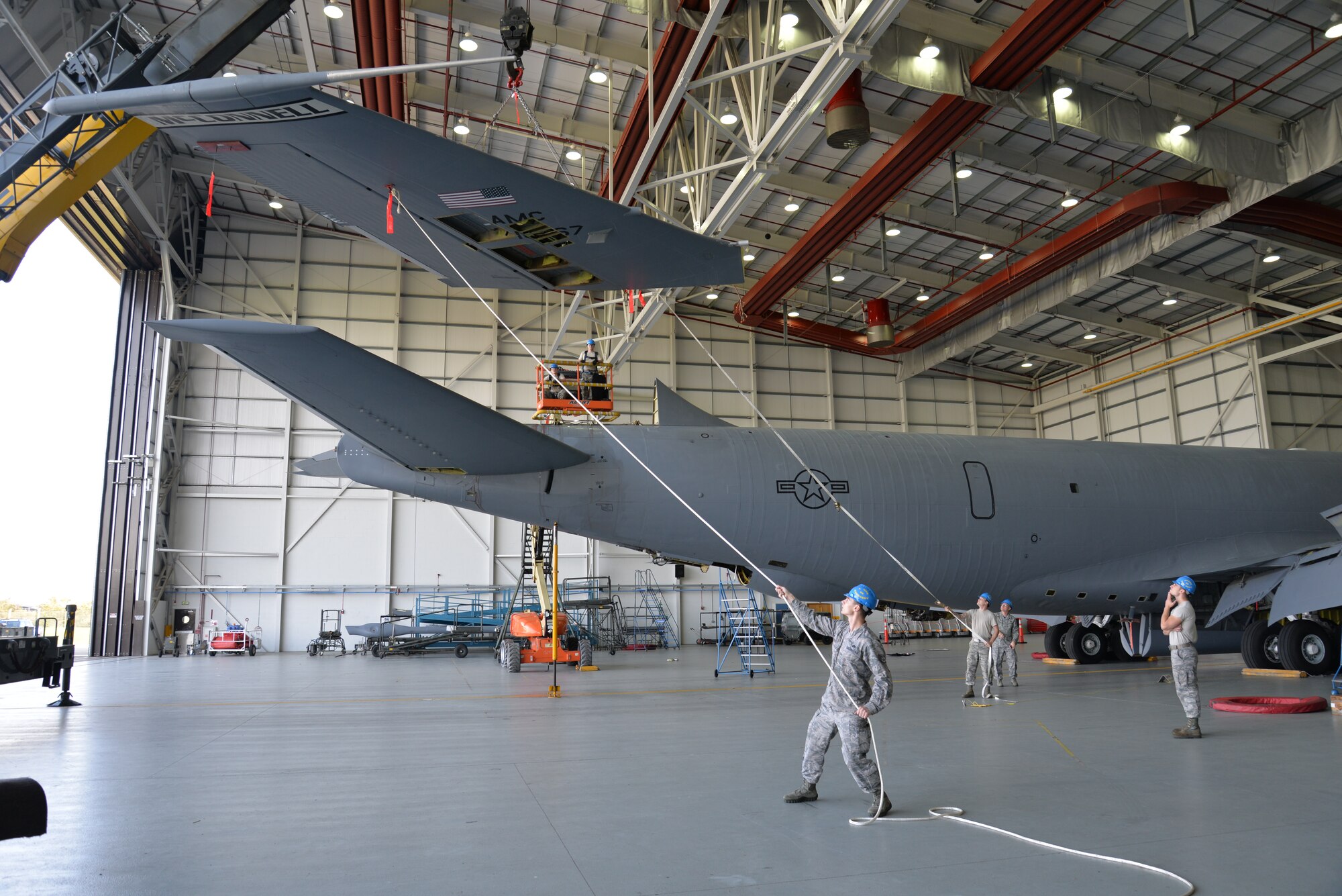 U.S. Air Force Airmen from the 100th Maintenance Squadron and 100th Aircraft Maintenance Squadron work together to perform a “fin fold” tail removal of a KC-135 Stratotanker Sept. 11, 2015, on RAF Mildenhall, England. The jet, formerly from McConnell Air Force Base, has been reassigned to RAF Mildenhall and underwent a full isochronal inspection, with the addition of the tail removal. It will soon be repainted and given the Square D markings. (U.S. Air Force photo by Karen Abeyasekere/Released)