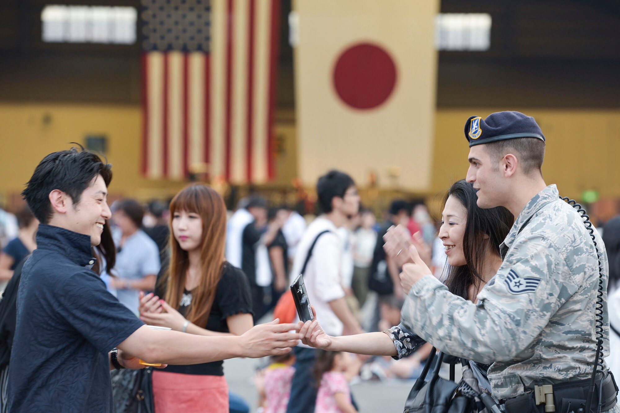 A woman prepares to take a photo with a 374th Security Forces Airman during the Japanese-American Friendship Festival at Yokota Air Base, Japan, Sept. 20, 2015. The annual festival is aimed at increasing bilateral relationships between the US and Japanese communities. (U.S. Air Force photo by Staff Sgt. Cody H. Ramirez/Released)