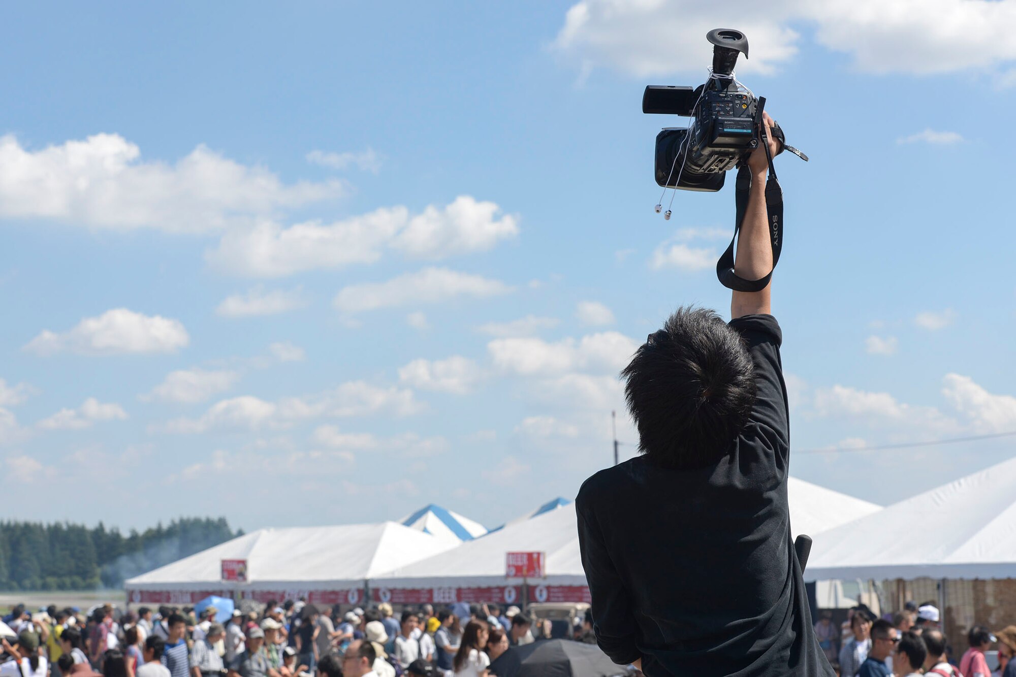 A cameraman captures video during the Japanese-American Friendship Festival at Yokota Air Base, Japan, Sept. 20, 2015. Fifty media representatives and 185,000 people attended the annual festival. (U.S. Air Force photo by Staff Sgt. Cody H. Ramirez/Released)
