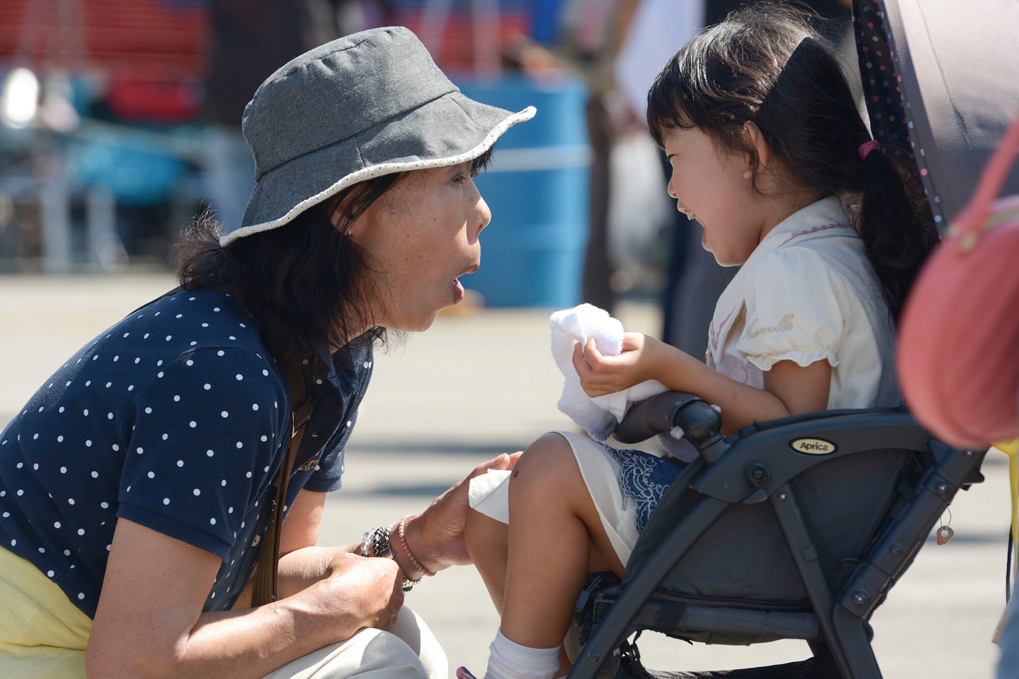 A grandmother teases her granddaughter during the Japanese-American Friendship Festival at Yokota Air Base, Japan, Sept. 20, 2015. Yokota hosted 28 display aircraft, food booths, entertainment and games during the annual festival. More than 185,000 people visited over the two-day event. (U.S. Air Force photo by Staff Sgt. Cody
H. Ramirez/Released)

