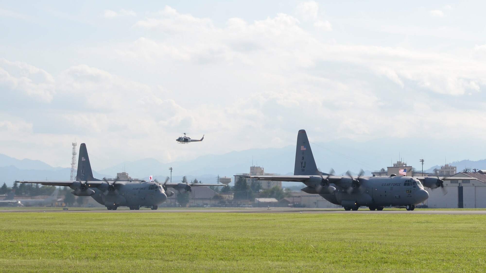 Service members hold US and Japanese national flags outside
C-130 Hercules during the Japanese-American Friendship Festival at Yokota Air Base, Japan, Sept. 20, 2015. More than 185,000 people attended the annual festival. (U.S. Air Force photo by Staff Sgt. Cody H. Ramirez/Released)
