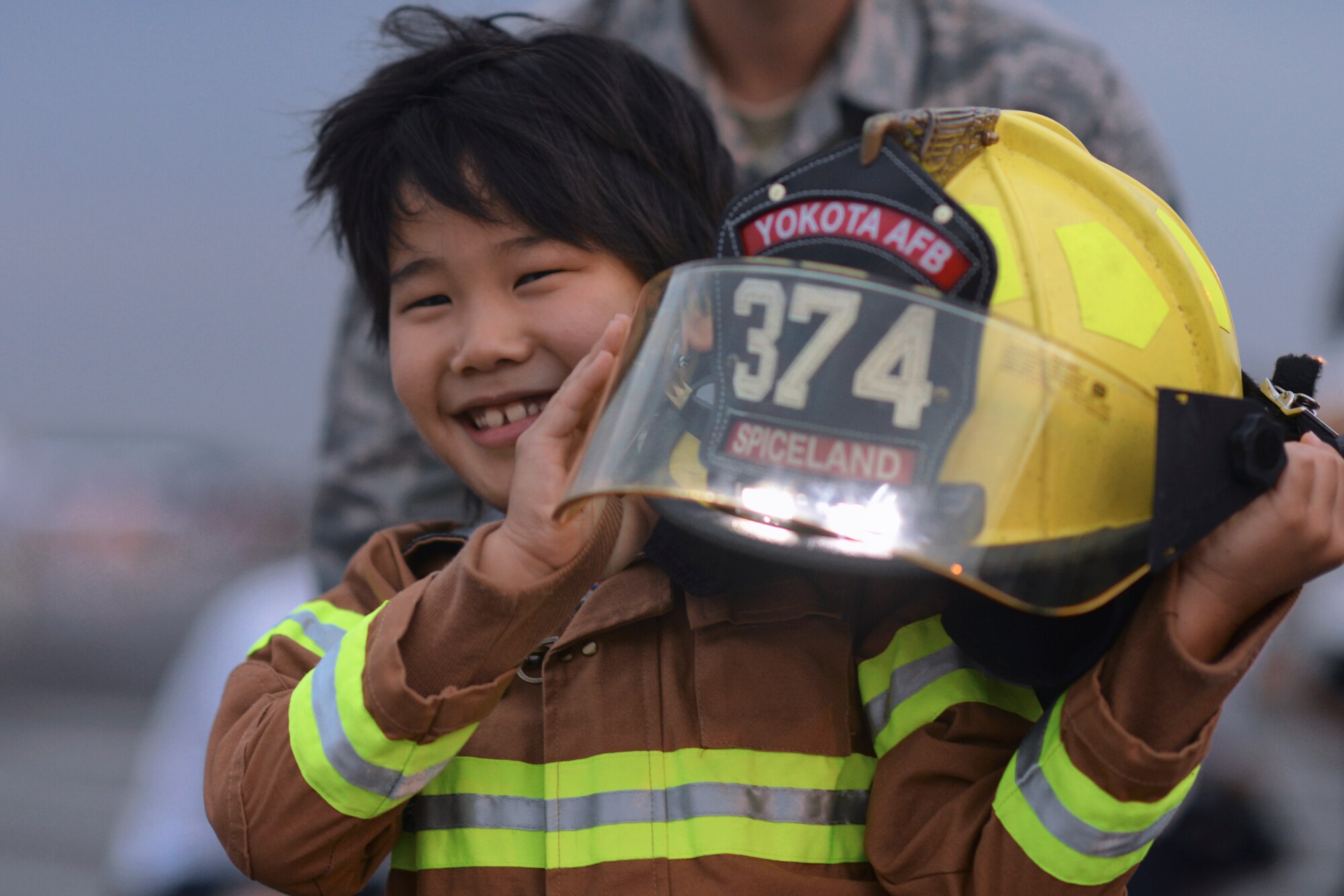 A young child puts on a firefighting suit during the Japanese-American Friendship Festival at Yokota Air Base, Japan, Sept. 20, 2015. The festival offered Japanese locals and Yokota members the opportunity to enjoy live performances, food booths and military capability demonstrations. (U.S. Air Force photo by Airman 1st Class Delano Scott/Released)
