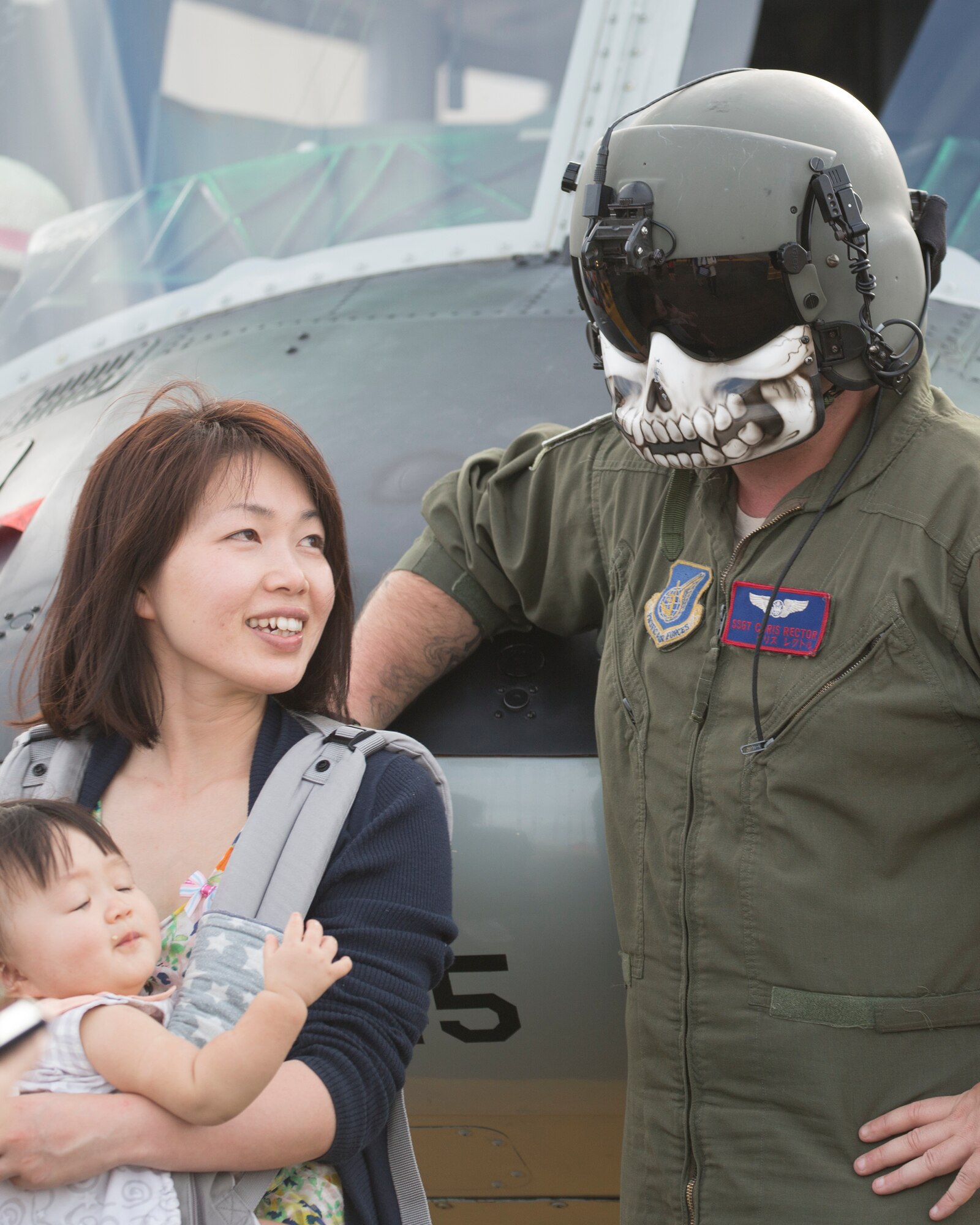 Staff Sgt. Christopher Rector, 459th Airlift Squadron flight engineer, poses for photos with a local guest at Yokota Air Base, Japan, during the Japanese-American Friendship Festival Sept. 19, 2015. Yokota welcomed 185,000 visitors for the festival. (U.S. Air Force photo by Osakabe Yasuo/Released) 