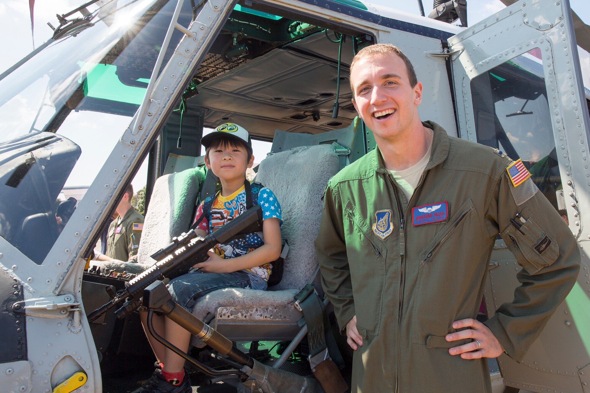 1st Lt. Jonathan Palka, 459th Airlift Squadron UH-1 pilot, poses for photos with a local boy at Yokota Air Base, Japan, during the Japanese-American Friendship Festival Sept. 19, 2015. Yokota welcomed 185,000 visitors for the festival. (U.S. Air Force photo by Osakabe Yasuo/Released)