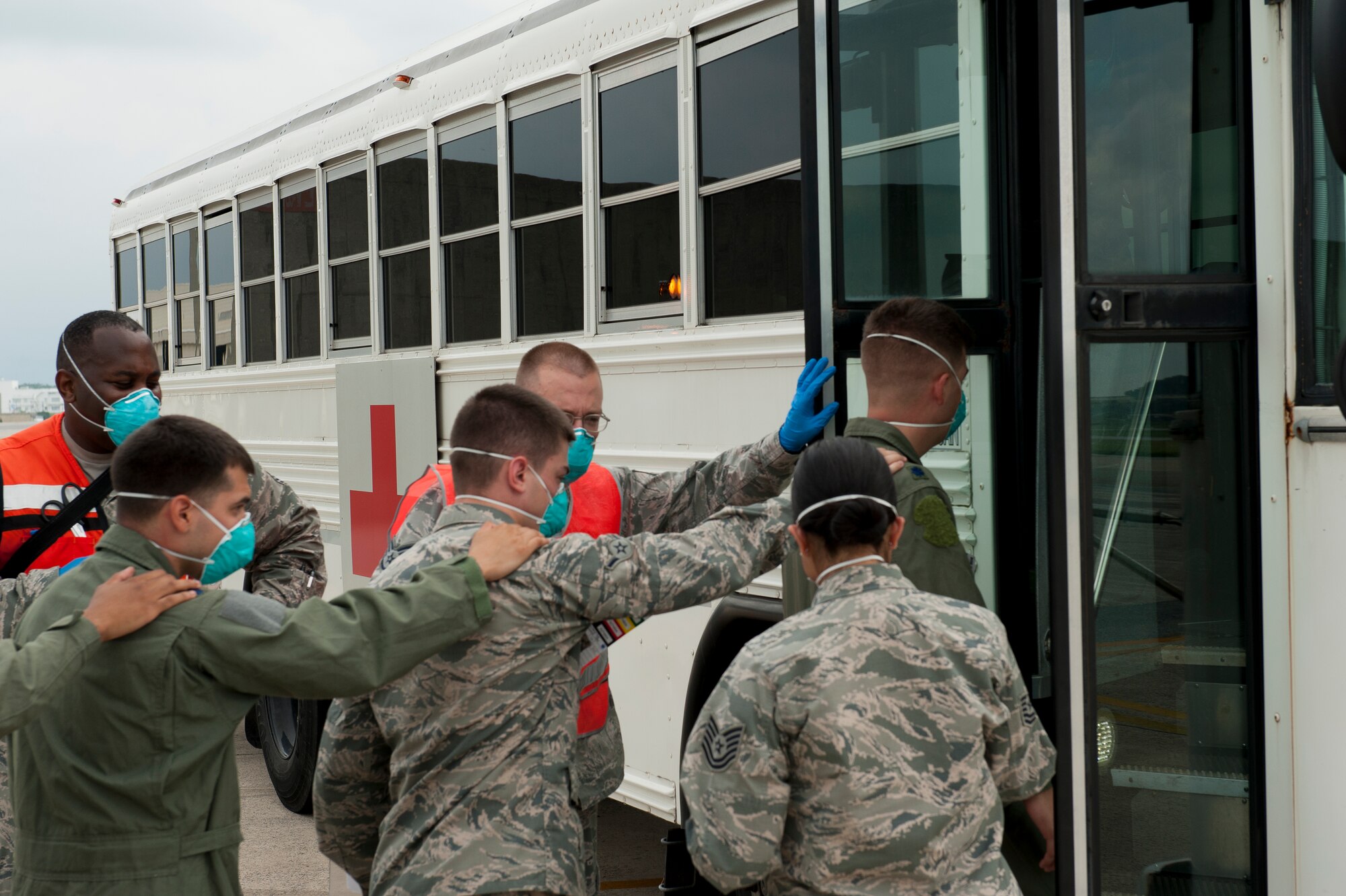 Personnel from the 18th Medical Group guide volunteers playing the part of a flight crew on to a medical bus for transport to a simulated quarantine zone during a medical emergency management exercise Sept. 21, 2015, at Kadena Air Base, Japan. The 18th MDG can face any number of unusual and life threatening situations, which is why exercises like this one play such an important part of their training. (U.S. Air Force photo by Airman 1st Class Zackary A. Henry)