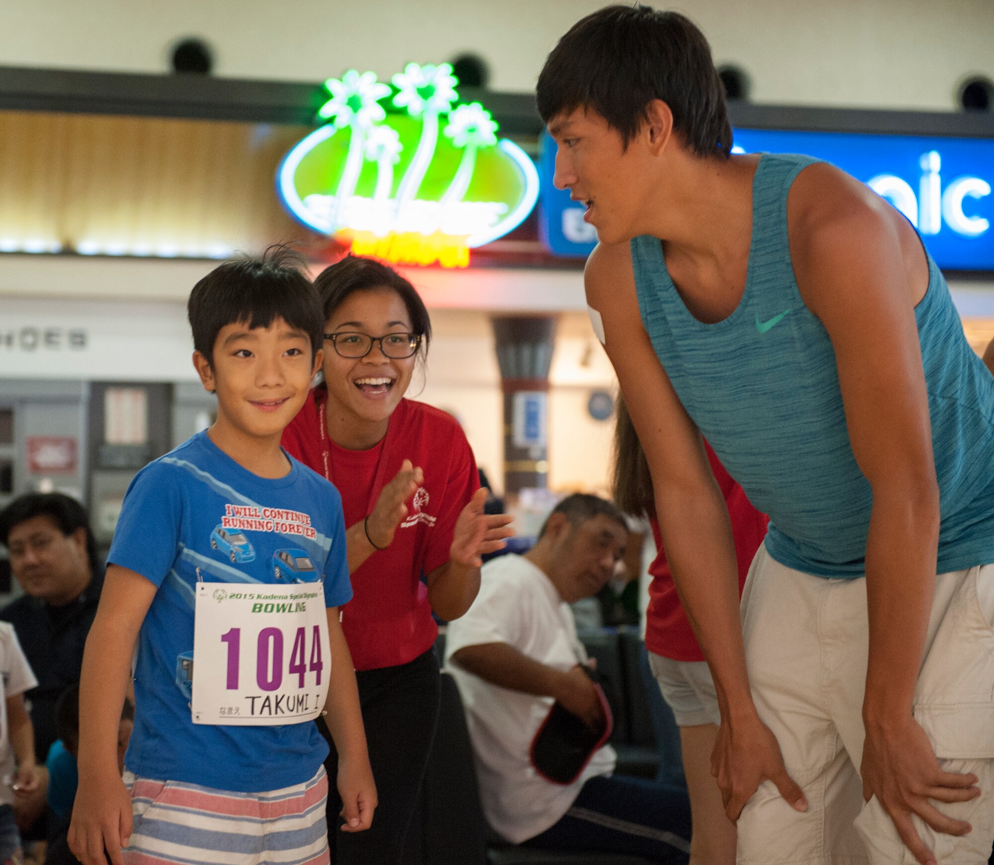 Shawn Monroe and Takara Maruo, high school students, congratulate Takumi, Kadena Special Olympics athlete, on bowling a strike during the KSO bowling event at Enagic Bowling in Mihama, Japan, Sept. 19, 2015. More than 300 people including athletes and their families packed into the bowling center to compete and cheer on their athletes. (U.S. Air Force photo by Airman 1st Class Corey M. Pettis)

