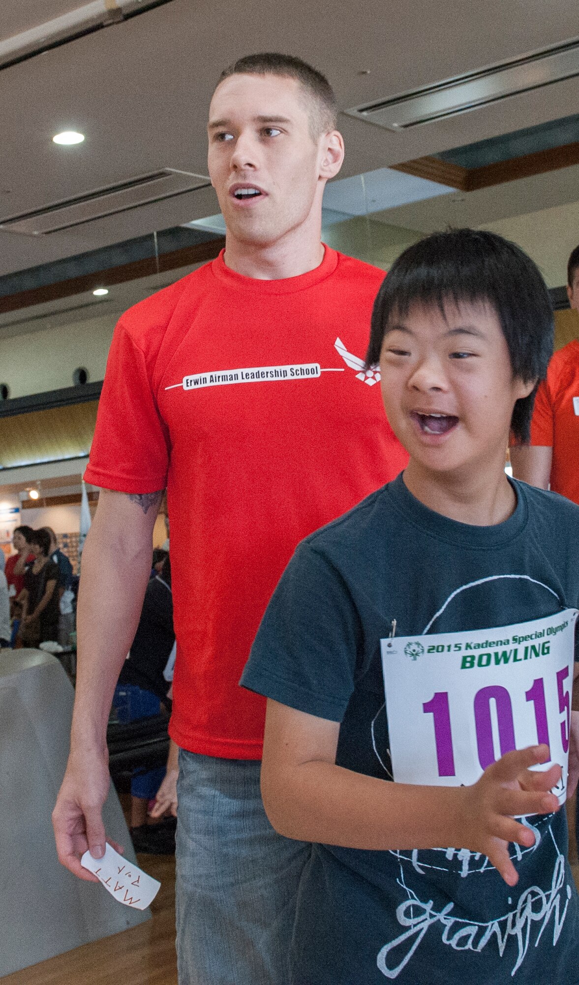 U.S. Air Force Staff Sgt. Matt Burns, 18th Wing Professional Military Education Center Airman Leadership School instructor, and Yuzuki, Kadena Special Olympics athlete, watch the bowling ball roll down the lane during the KSO bowling event at Enagic Bowling in Mihama, Japan, Sept. 19, 2015. Bowling kicks off KSO as the first competition in a series of many events. (U.S. Air Force photo by Airman 1st Class Corey M. Pettis)