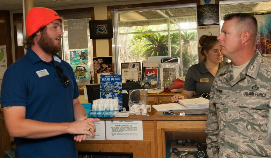 U.S. Air Force Chief Master Sgt. Charles Hoffman, 18th Wing command chief, talks with Bob Scott, Kadena Marina supervisory recreation assistant, about the programs the Kadena Marina offers in support of Project 22 Sept. 21, 2015, on Kadena Air Base, Japan. Part of suicide prevention is resiliency and Project 22 aims to raise awareness to programs that help Airmen cope with stress. (U.S. Air Force photo by Airman 1st Class Corey M. Pettis)