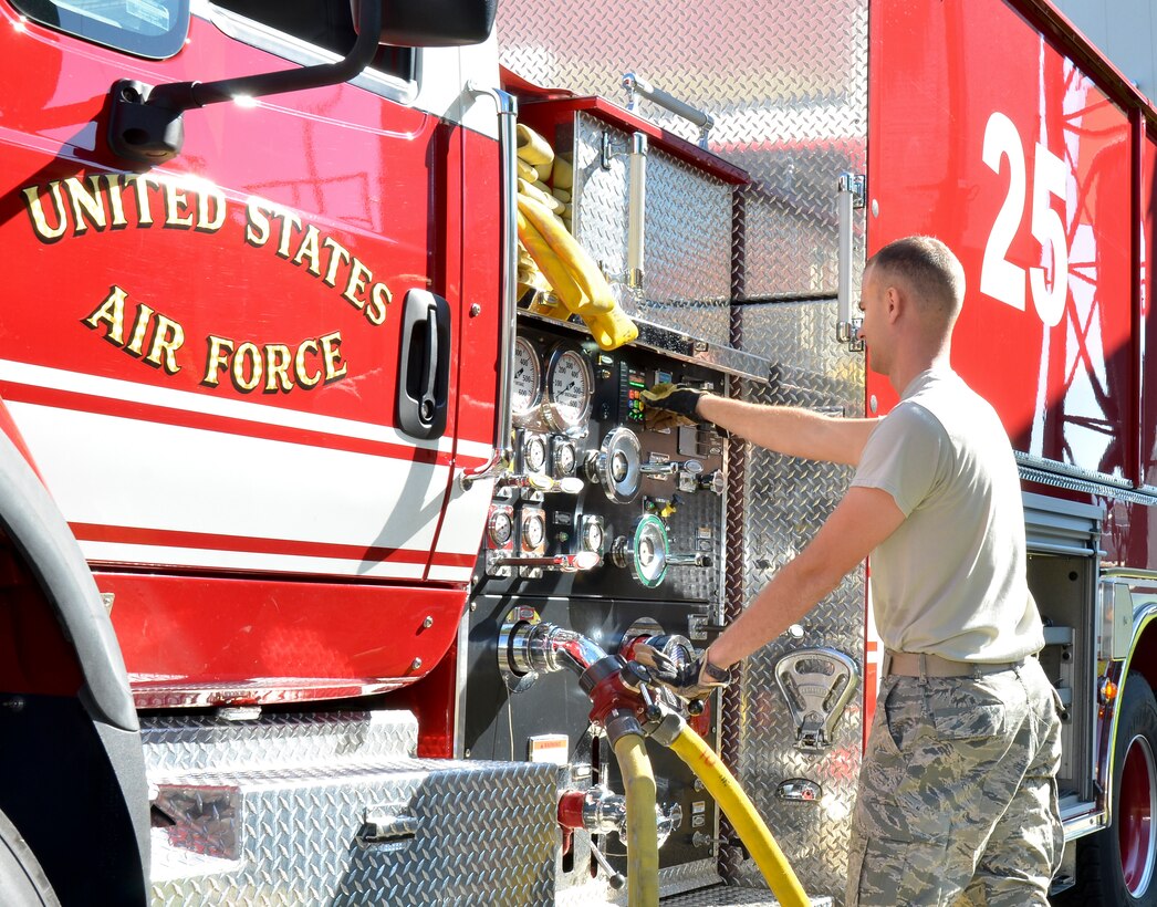 Firefighters from the Civil Engineering Squadron practice fighting structure fires as a part of their annual training at the 117th Air Refueling Wing on September 19, 2015. The firefighters used a travel trailer and other equipment to simulate structure fires caused by propane gas. According to Master Sgt. Brian Garvich, their main strategy in fighting these fires was to utilize the “two-in, two-out” policy which mandates that firefighters never enter a building alone during a rescue mission. Two firefighters act as a team entering the structure and another two-person team is waiting outside the hazard dedicated to rescuing those inside, should they need it. (U.S. Air National Guard photo  by Staff Sgt. Jeremy Farson/Released)