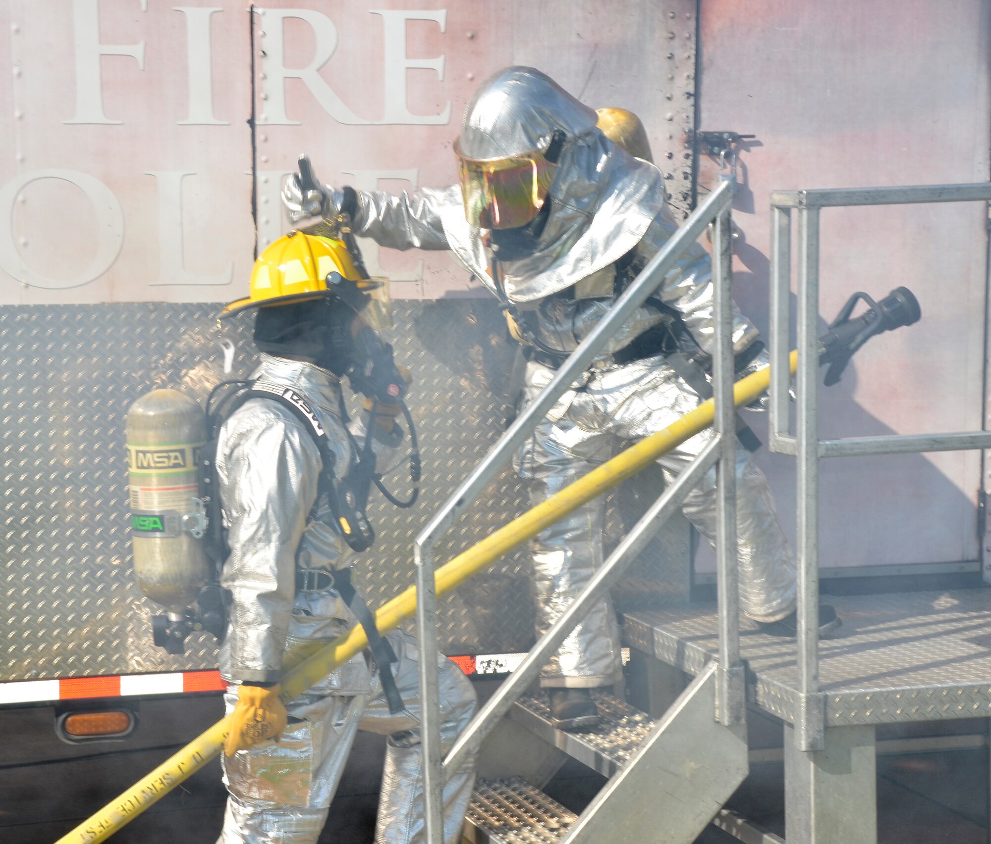 Firefighters from the Civil Engineering Squadron practice fighting structure fires as a part of their annual training at the 117th Air Refueling Wing on September 19, 2015. The firefighters used a travel trailer and other equipment to simulate structure fires caused by propane gas. According to Master Sgt. Brian Garvich, their main strategy in fighting these fires was to utilize the “two-in, two-out” policy which mandates that firefighters never enter a building alone during a rescue mission. Two firefighters act as a team entering the structure and another two-person team is waiting outside the hazard dedicated to rescuing those inside, should they need it. (U.S. Air National Guard photo  by Staff Sgt. Jeremy Farson/Released)