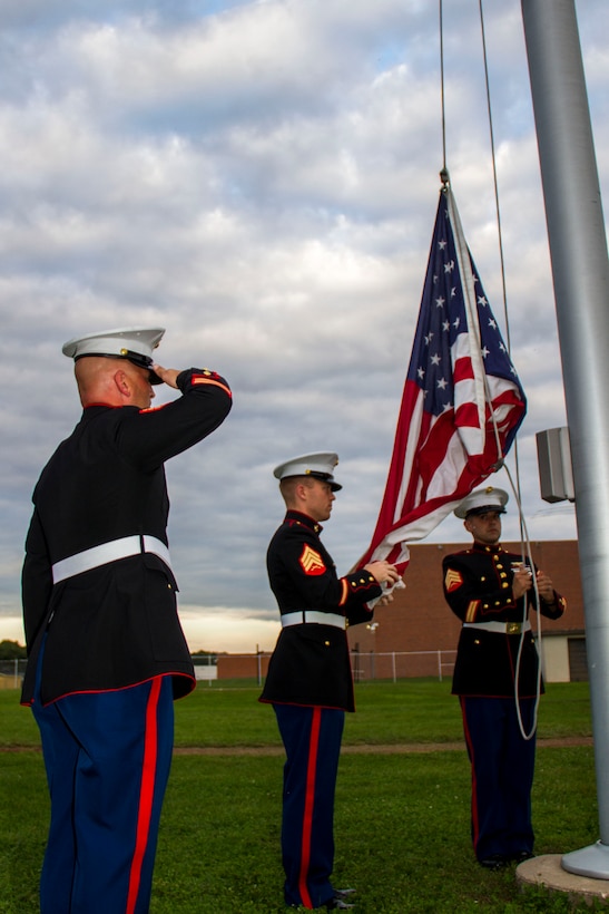 Marines from Recruiting Substation Central Michigan raise the United States flag during the H.H. Dow vs. Flint Southwestern football game, Sept. 18, 2015. The game was part of a Wounded Warriors Project fund drive.