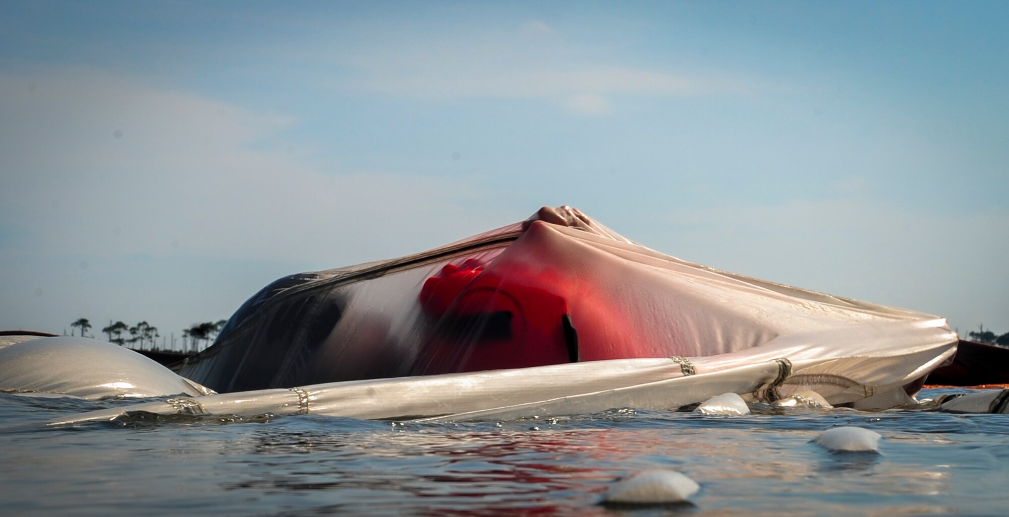 An aircrew member swims under a canopy during survival, evasion, resistance and escape during fixed-wing survival canopy disentanglement training at Hurlburt Field, Fla., Sept. 1, 2015. The training was part of a fixed-wing water survival training conducted tri-annually to maintain proficiency on skill sets such as canopy disentanglement, parachute drop and drag and life raft boarding. (U.S. Air Force photo by Senior Airman Meagan Schutter)