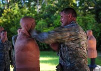 Staff Sgt. Seth Sarrett, 1st Special Operation Squadron survival, evasion, resistance and escape specialist, demonstrates combative techniques to aircrew during combat survival training at Hurlburt Field, Fla., Sept. 2, 2015. Aircrew members train tri-annually to maintain proficiency on skill sets such as combative, evasion, navigation, signaling, radio use and discipline and contact procedures. (U.S. Air Force photo by Senior Airman Meagan Schutter)
