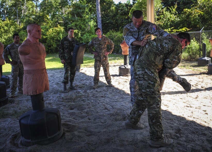 Staff Sgt. Seth Sarrett, 1st Special Operations Squadron survival, evasion, resistance and escape specialist, demonstrates combative techniques to aircrew members during combat survival training at Hurlburt Field, Fla., Sept. 2, 2015. Aircrew members participate in combat survival training tri-annually to maintain proficiency on skill sets such as combative, evasion, navigation, signaling, radio use and discipline and contact procedures. (U.S. Air Force photo by Senior Airman Meagan Schutter)