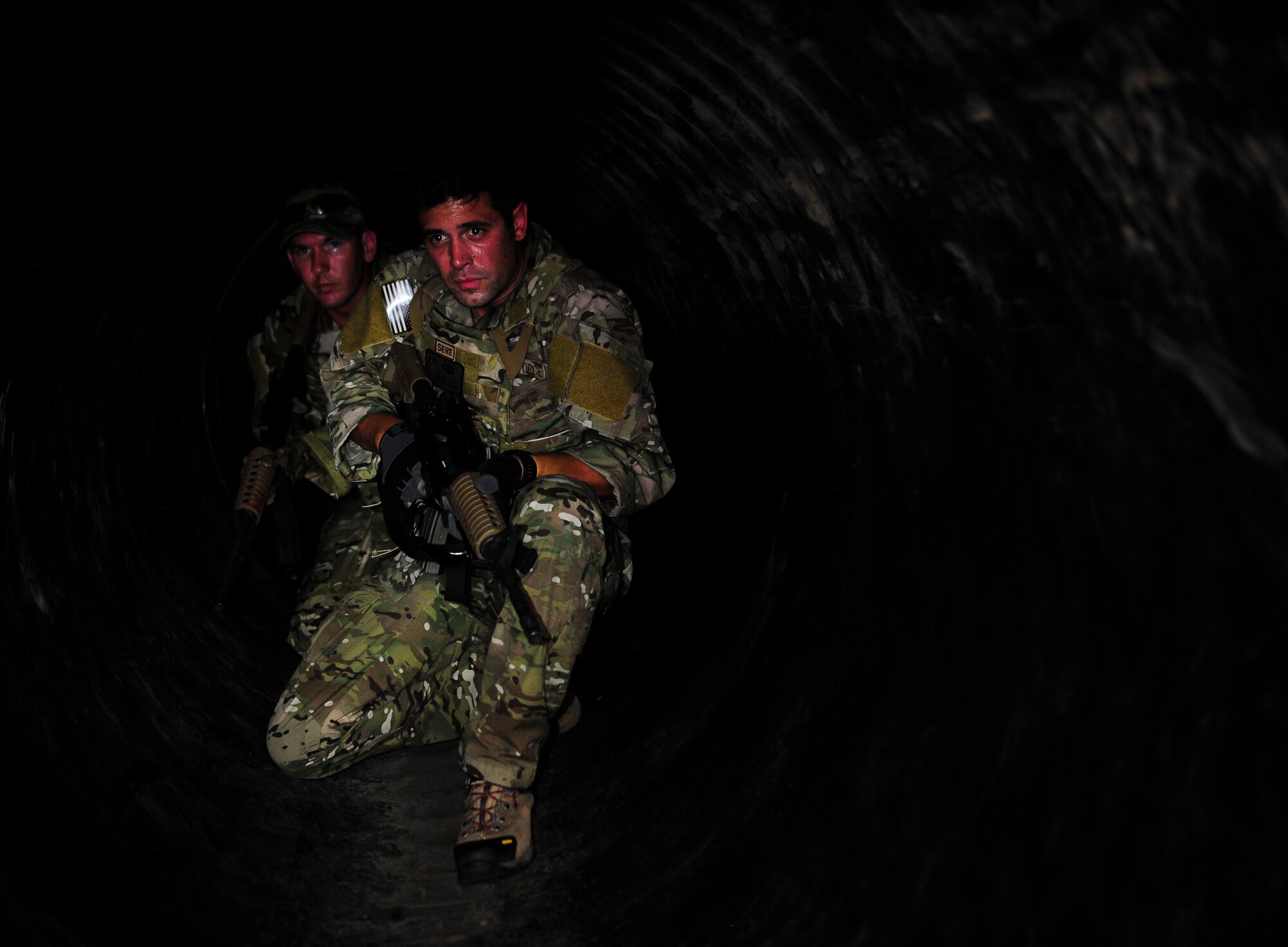 Senior Airmen Justin Covieo and Tommy Dreher, 1st Special Operations Support Squadron survival, evasion, resistance and escape specialists walk through an underground tunnel during urban clearing training at Eglin Field Complex, Fla., Sept. 2, 2015. Aircrew members participate in combat survival training tri-annually to maintain proficiency on skill sets such as combative, evasion, navigation, signaling, radio use and discipline and contact procedures. (U.S. Air Force photo by Senior Airman Meagan Schutter)