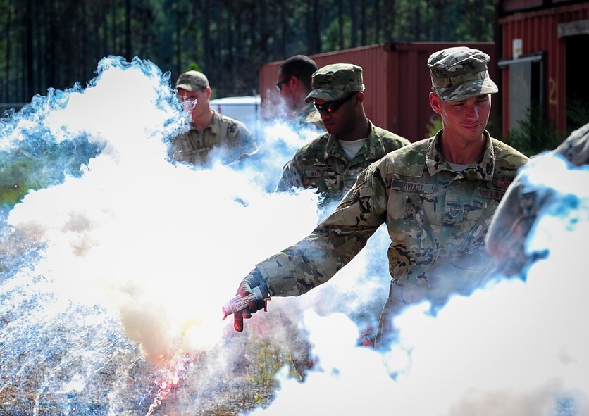 Aircrew members light signal flares during urban clearing training at Eglin Field Complex, Fla., Sept. 2, 2015. Aircrew members participate in combat survival training tri-annually to maintain proficiency on skill sets such as combative, evasion, navigation, signaling, radio use and discipline and contact procedures. (U.S. Air Force photo by Senior Airman Meagan Schutter)