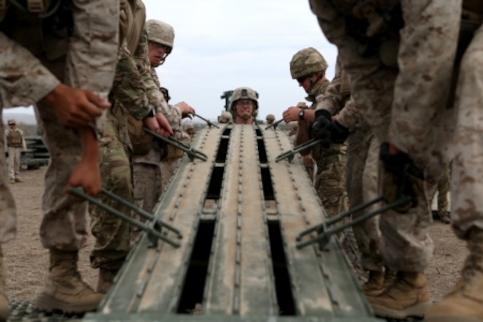 Engineers from Bridge Company, 7th Engineer Support Battalion, 1st Marine Logistics Group and 1st Combat Engineer Battalion, 1st Marine Division work with members of British 54 Commando Squadron Royal Engineers to place a ramp on a medium girder bridge aboard Camp Pendleton, Calif., Sept. 21, 2015. Marines from 7th ESB and 1st CEB are conducting various engineer training events alongside their British counterparts in coming weeks as part of annual large-scale exercise Black Alligator.